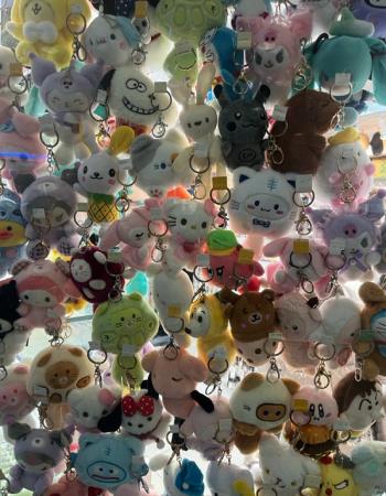A dense collection of colorful plush cartoon character keychains hanging together.