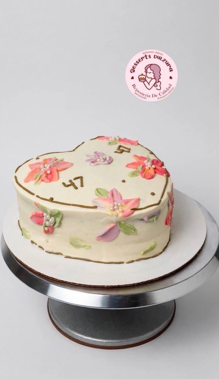 Pastel en forma de corazón decorado con flores pintadas y perlas