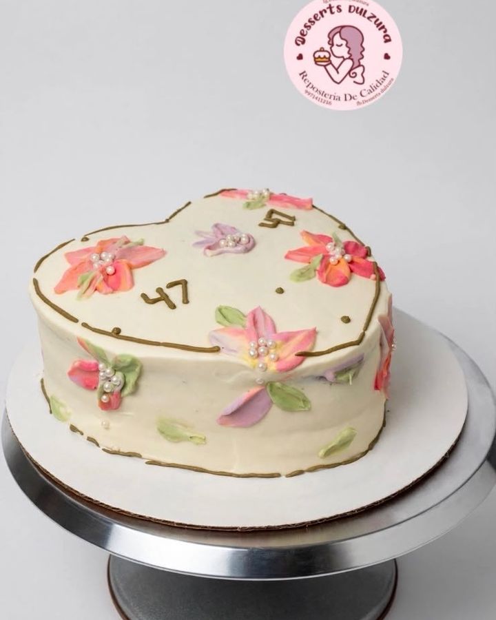 Pastel en forma de corazón decorado con flores pintadas y perlas