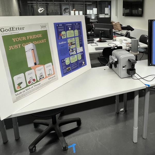 A photo of a stand showing the GodEtter physical prototype and posters of the solution..