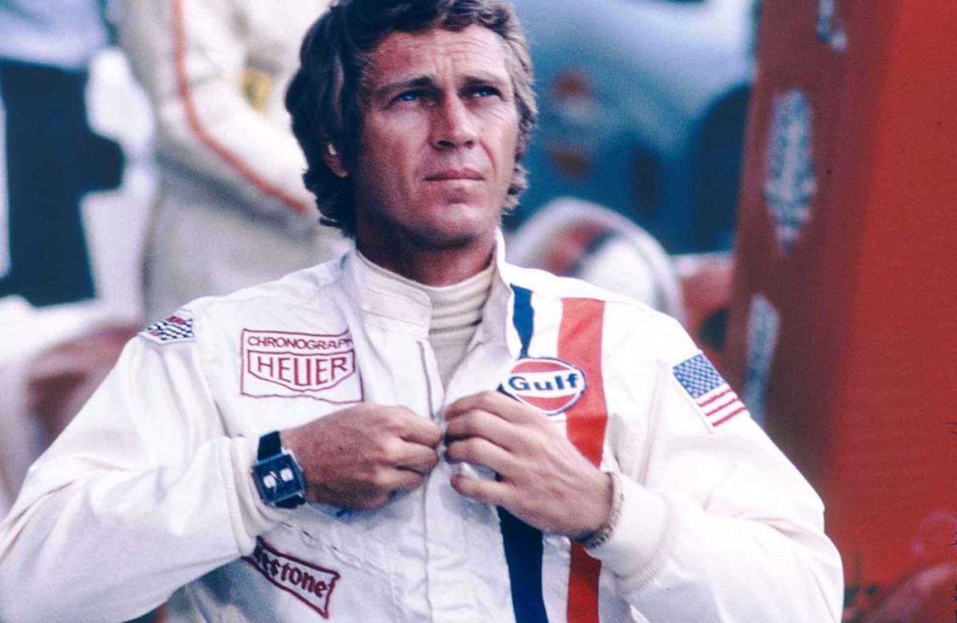 Steve McQueen com roupas de corrida e relógio clássico