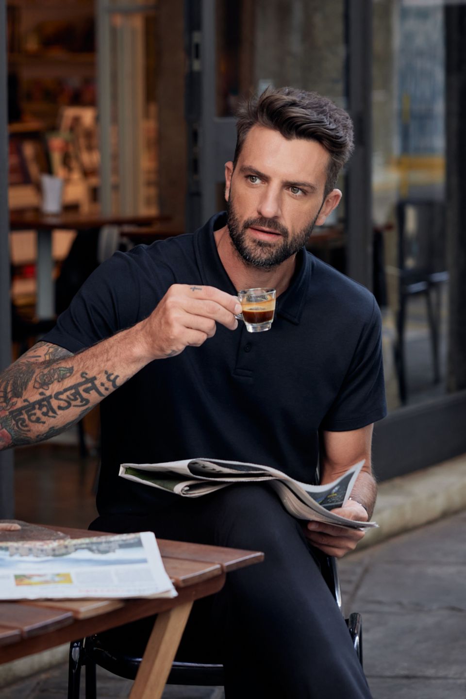 homem tomando café lendo jornal