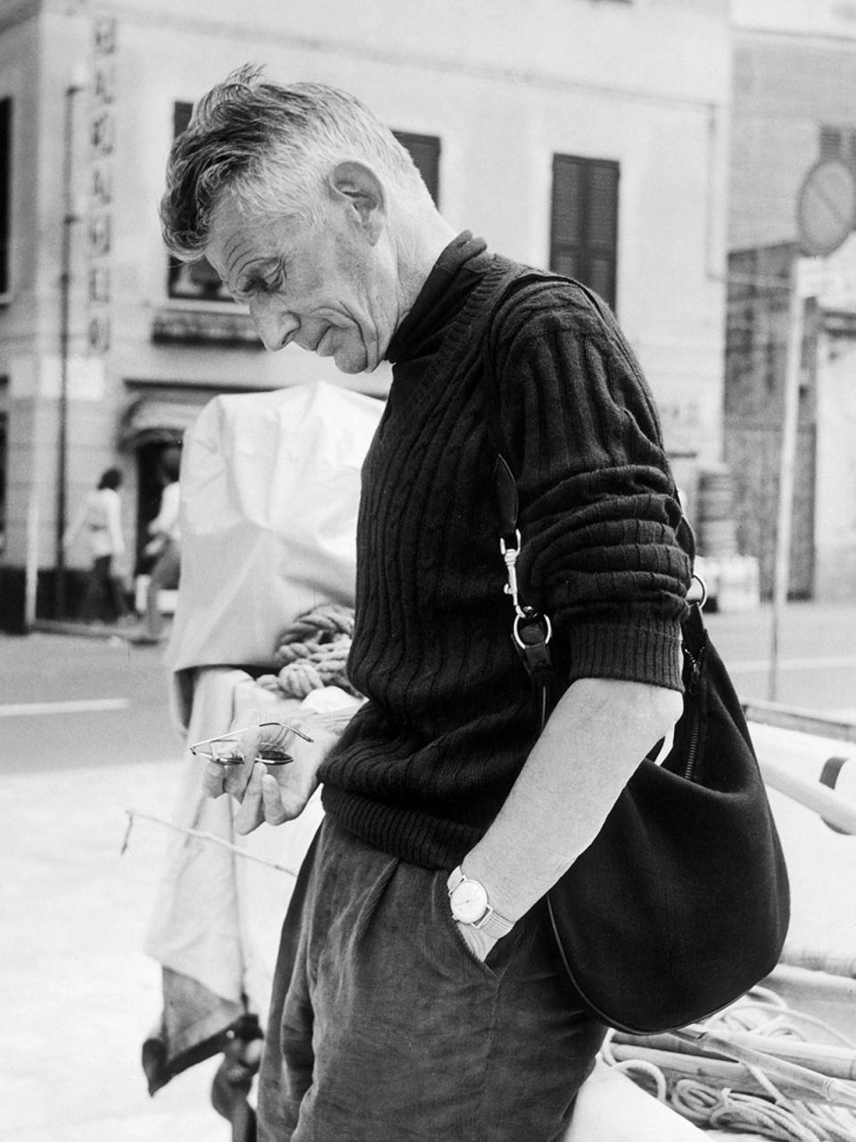 Samuel Beckett usando roupas de alfaitaria com um suéter gola alta
