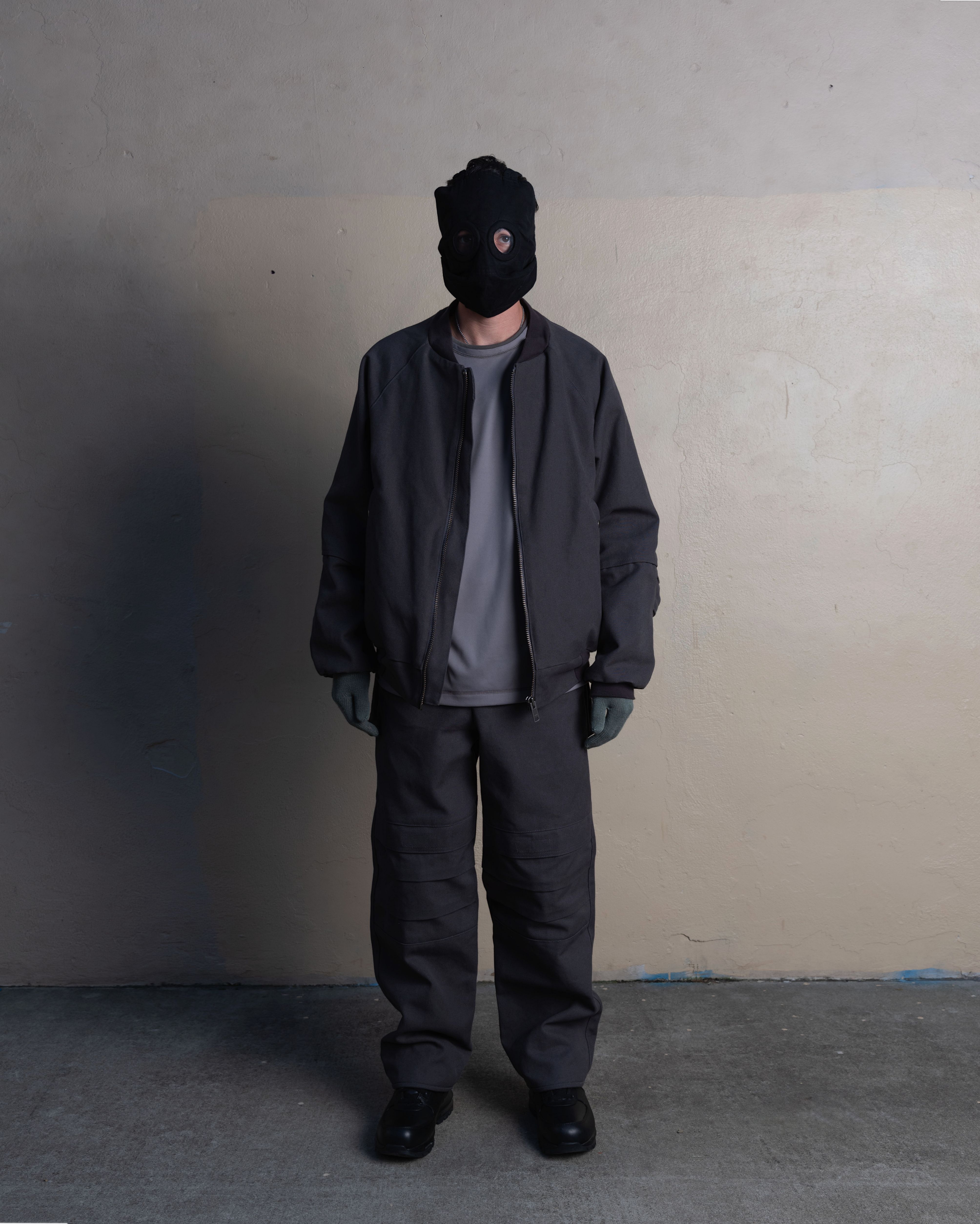 man wearing rocket conductor mask, lunar bomber, and knee cargo trousers from bryan jimenez spring summer 2023
