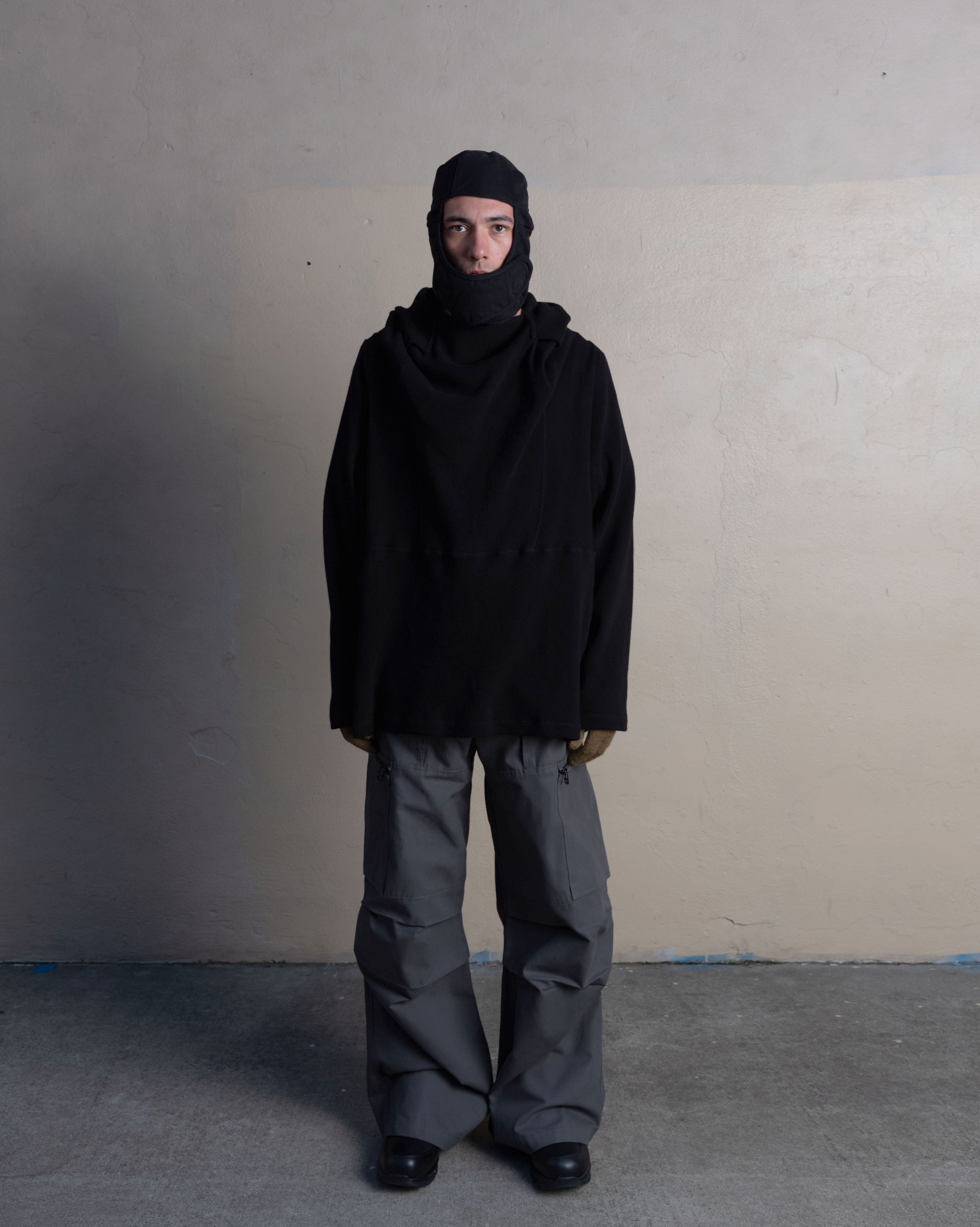 man wearing helmet liner cap, armstrong hoodie, and cargo uniform trousers from bryan jimenez spring summer 2023