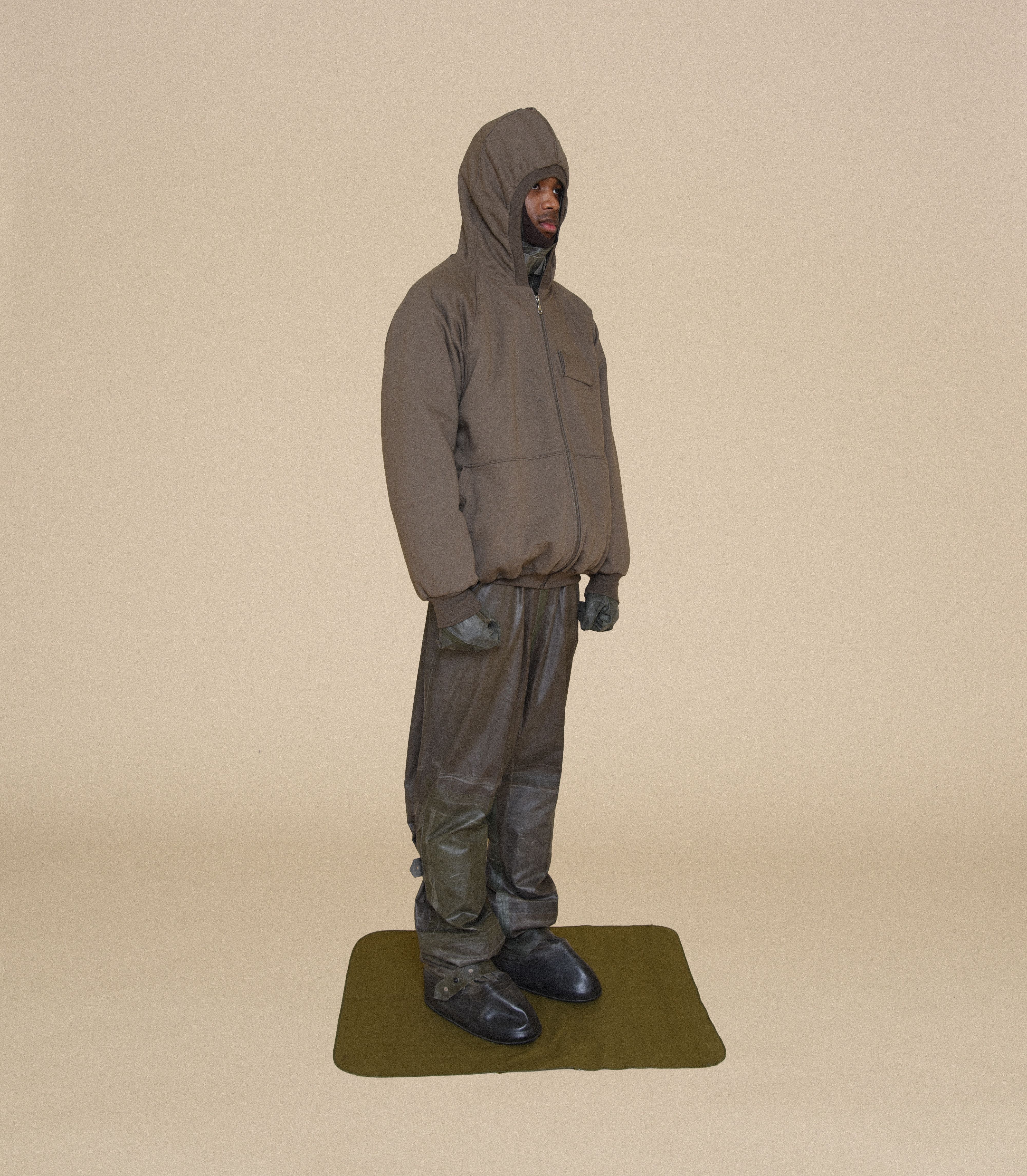 Man wearing MK HOODIE, ARCTIC BALACLAVA, RUBBER SNIPER GLOVES and COVER SUIT From Bryan Jimenez fall/winter 2023.