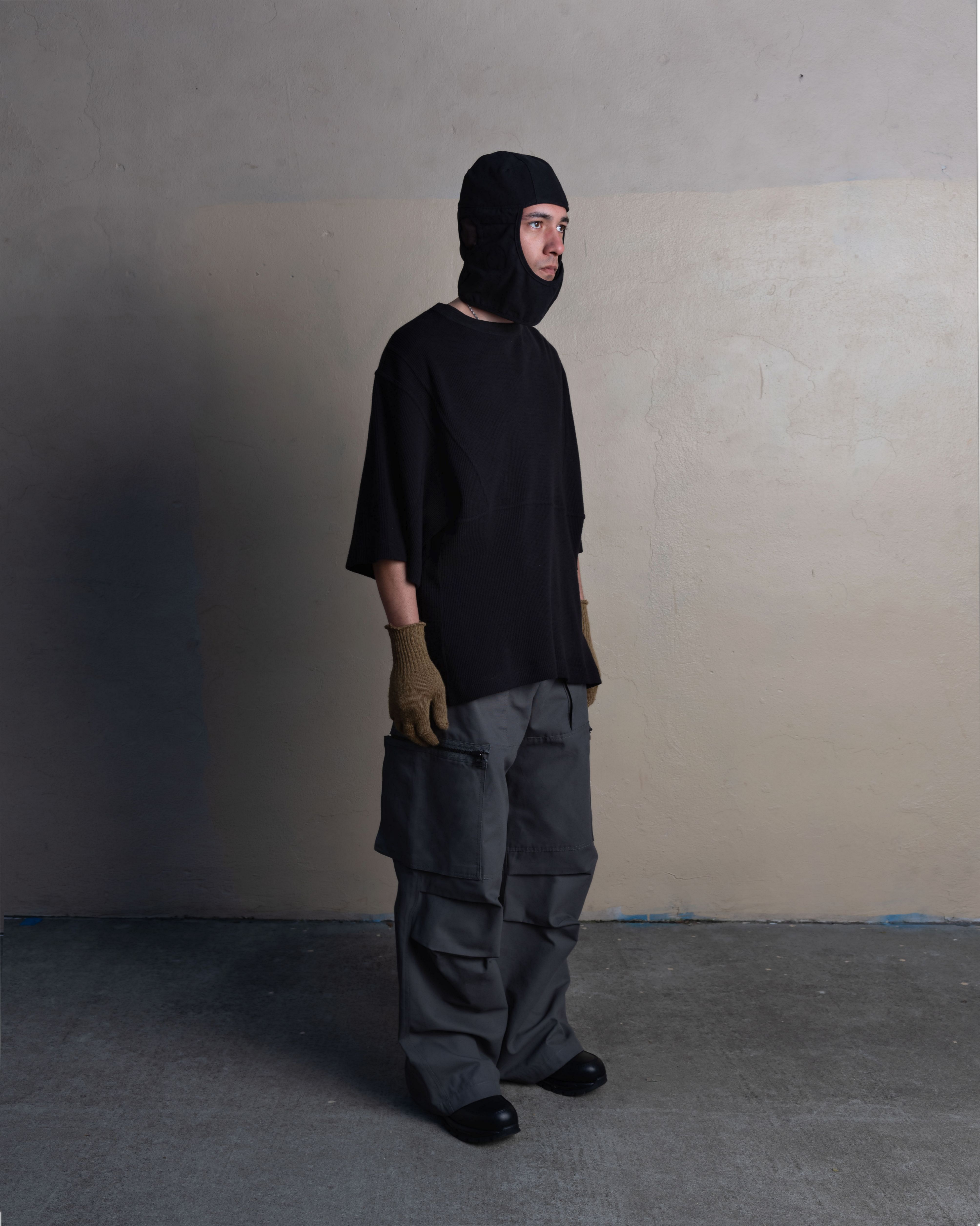 man wearing helmet liner cap, thermal tee, and cargo uniform trousers from bryan jimenez spring summer 2023