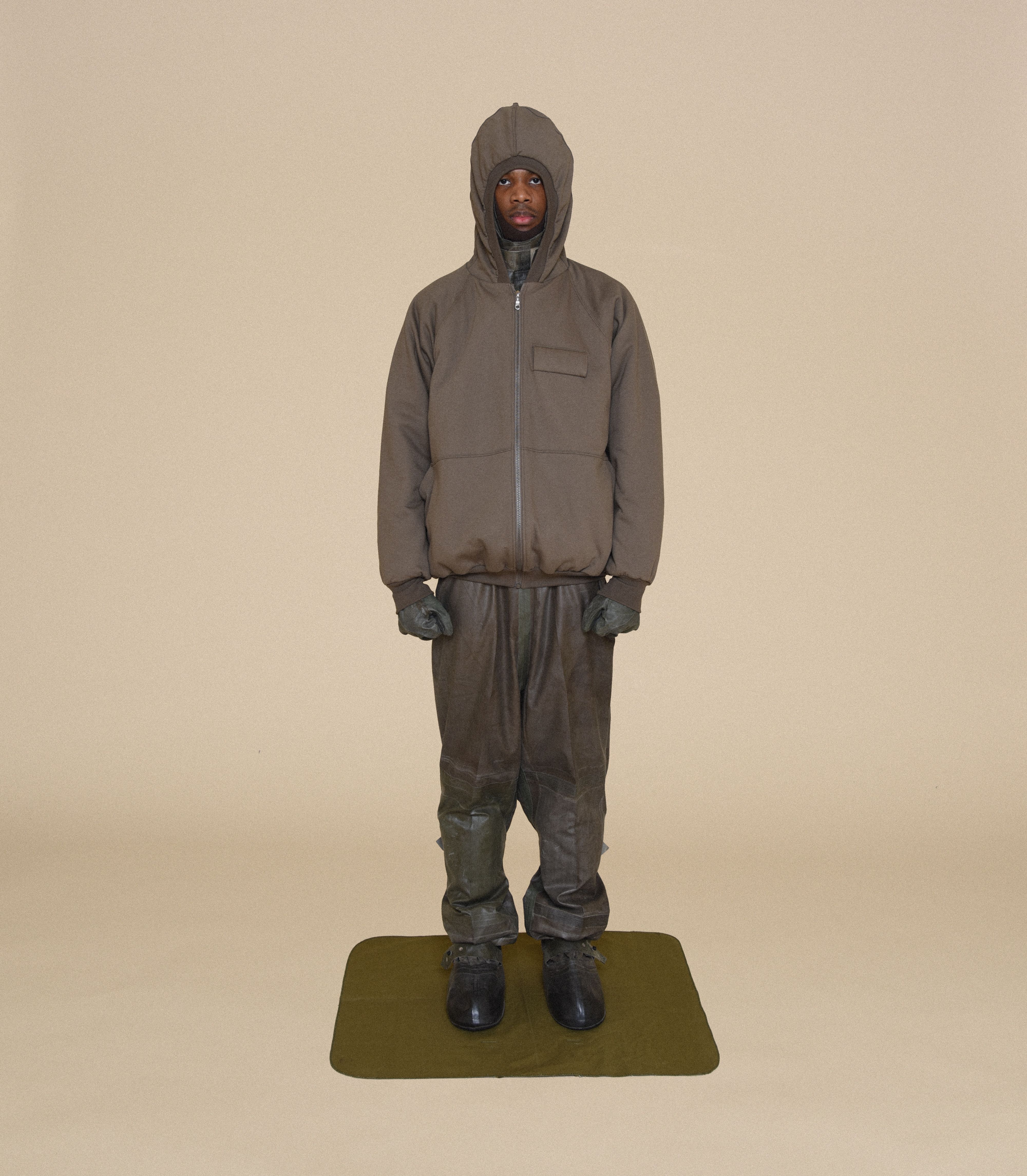 Man wearing MK HOODIE, ARCTIC BALACLAVA, RUBBER SNIPER GLOVES and COVER SUIT From Bryan Jimenez fall/winter 2023.