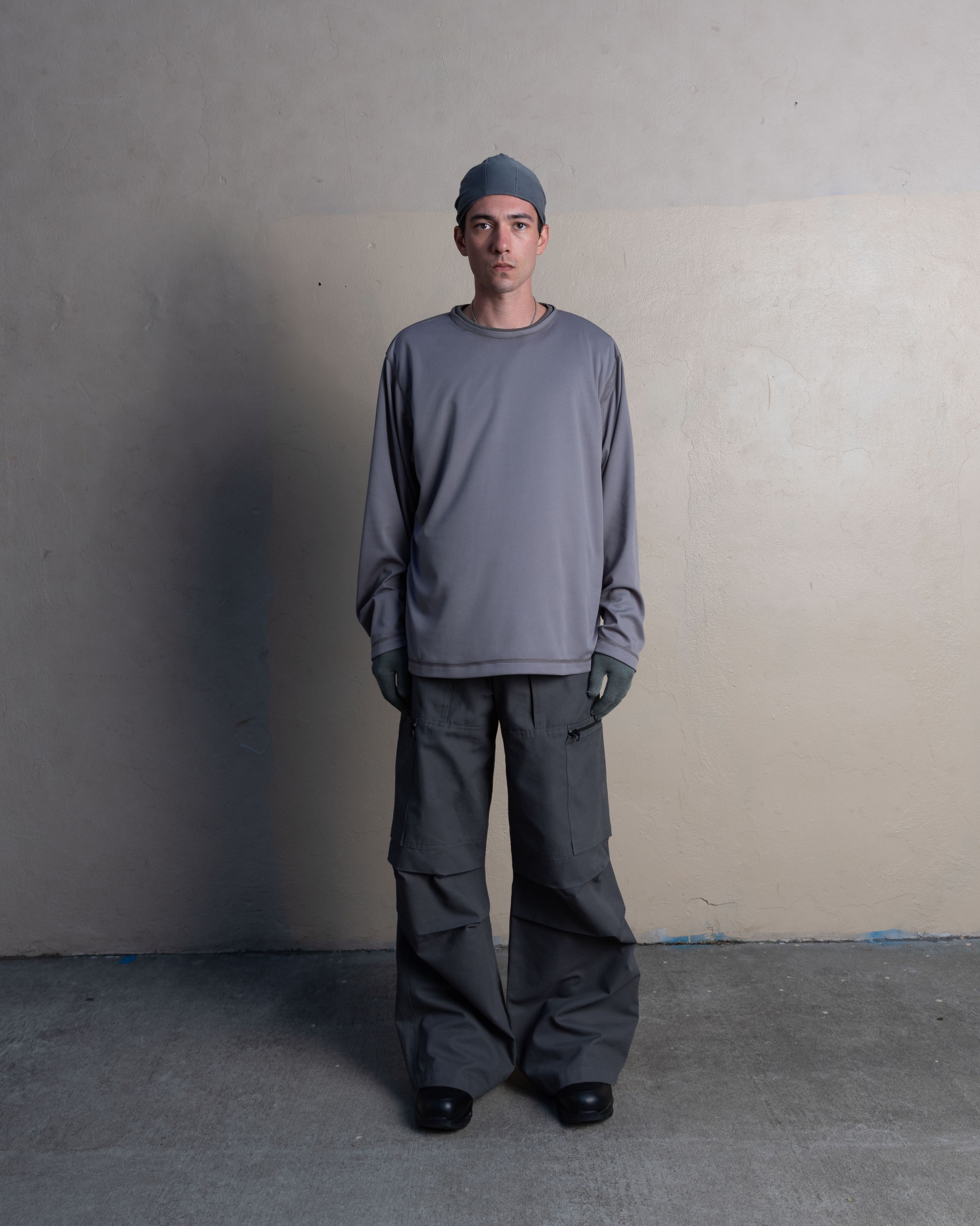 man wearing silk weight top, skull cap, and cargo uniform trousers from bryan jimenez spring summer 2023 