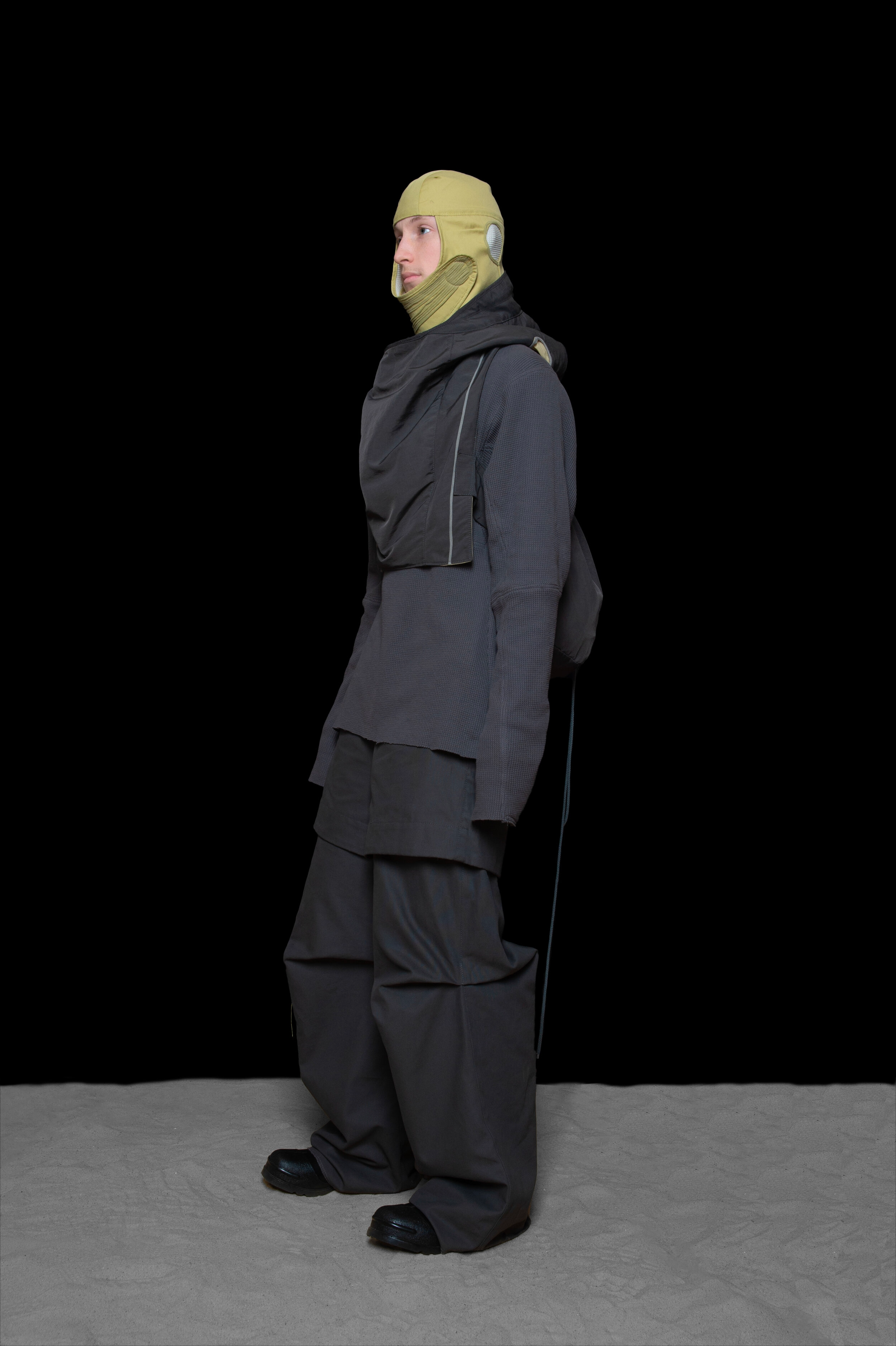 man wearing head liner cap, oxygen hoodied vest bag, thermal jumper, and layered trouser from bryan jimenez fall winter 2020