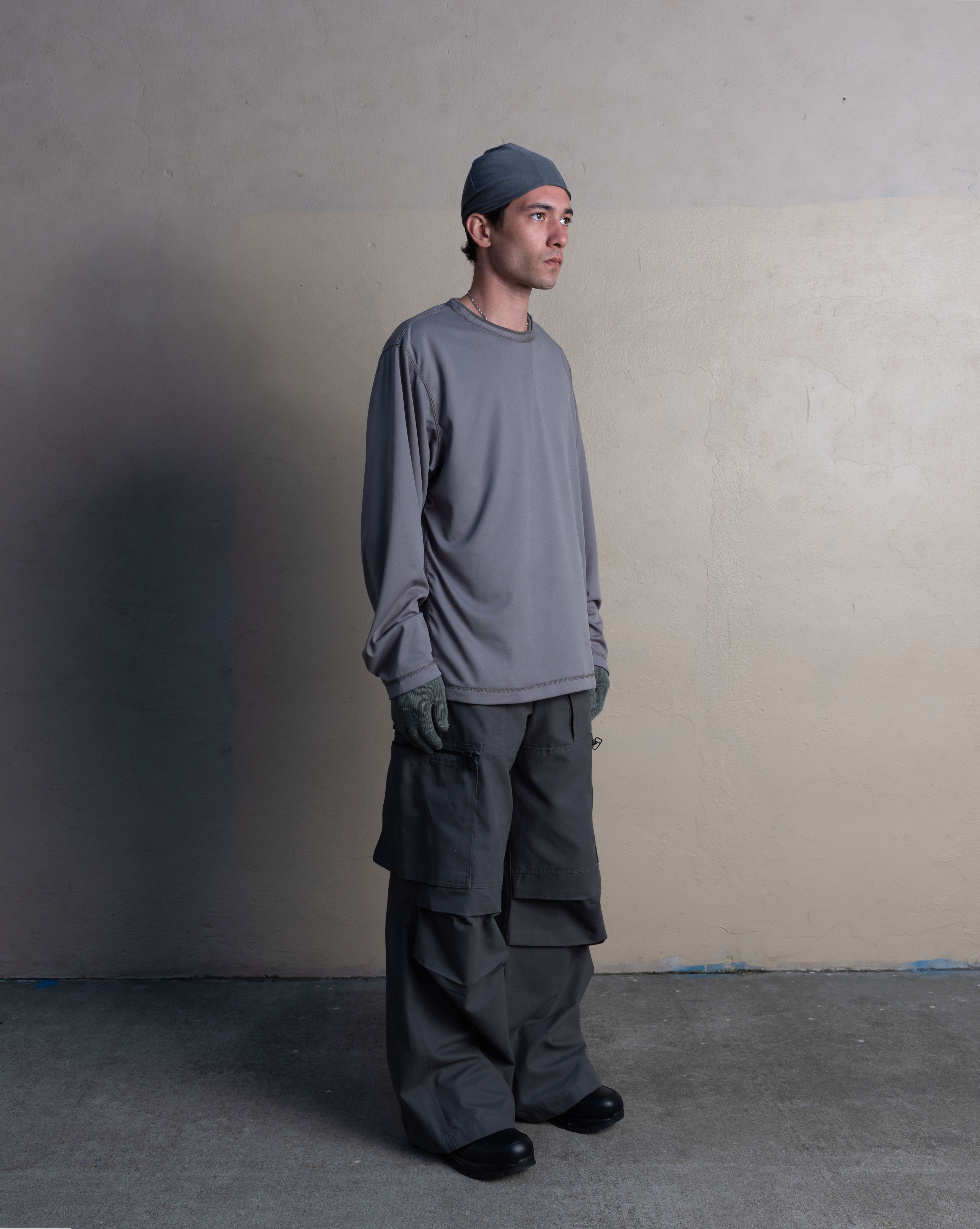 man wearing silk weight top, skull cap, and cargo uniform trousers from bryan jimenez spring summer 2023 
