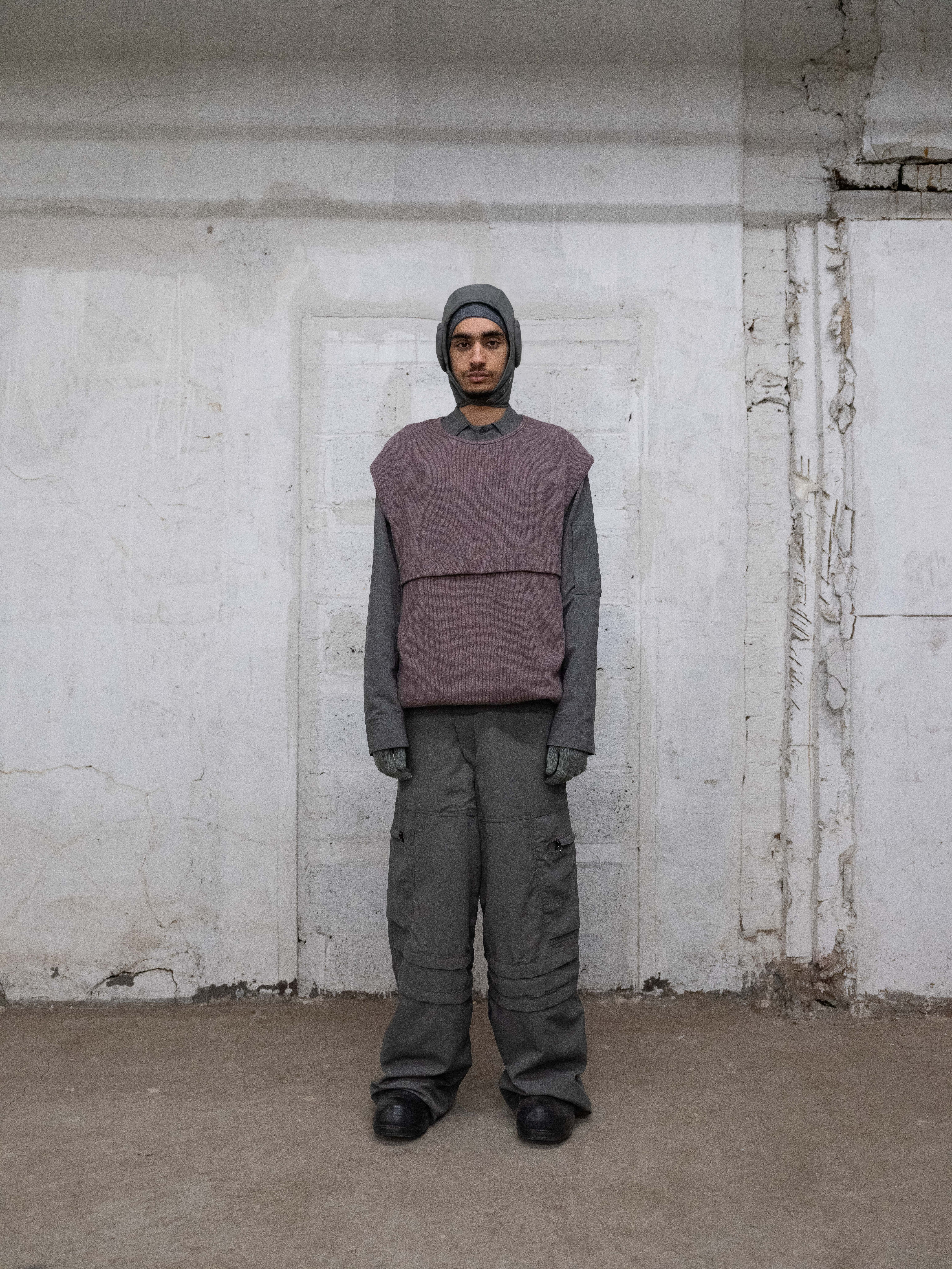 man weariing snoopy cap, space worker vest, and station trousers from bryan jimenez fall/winter 2022