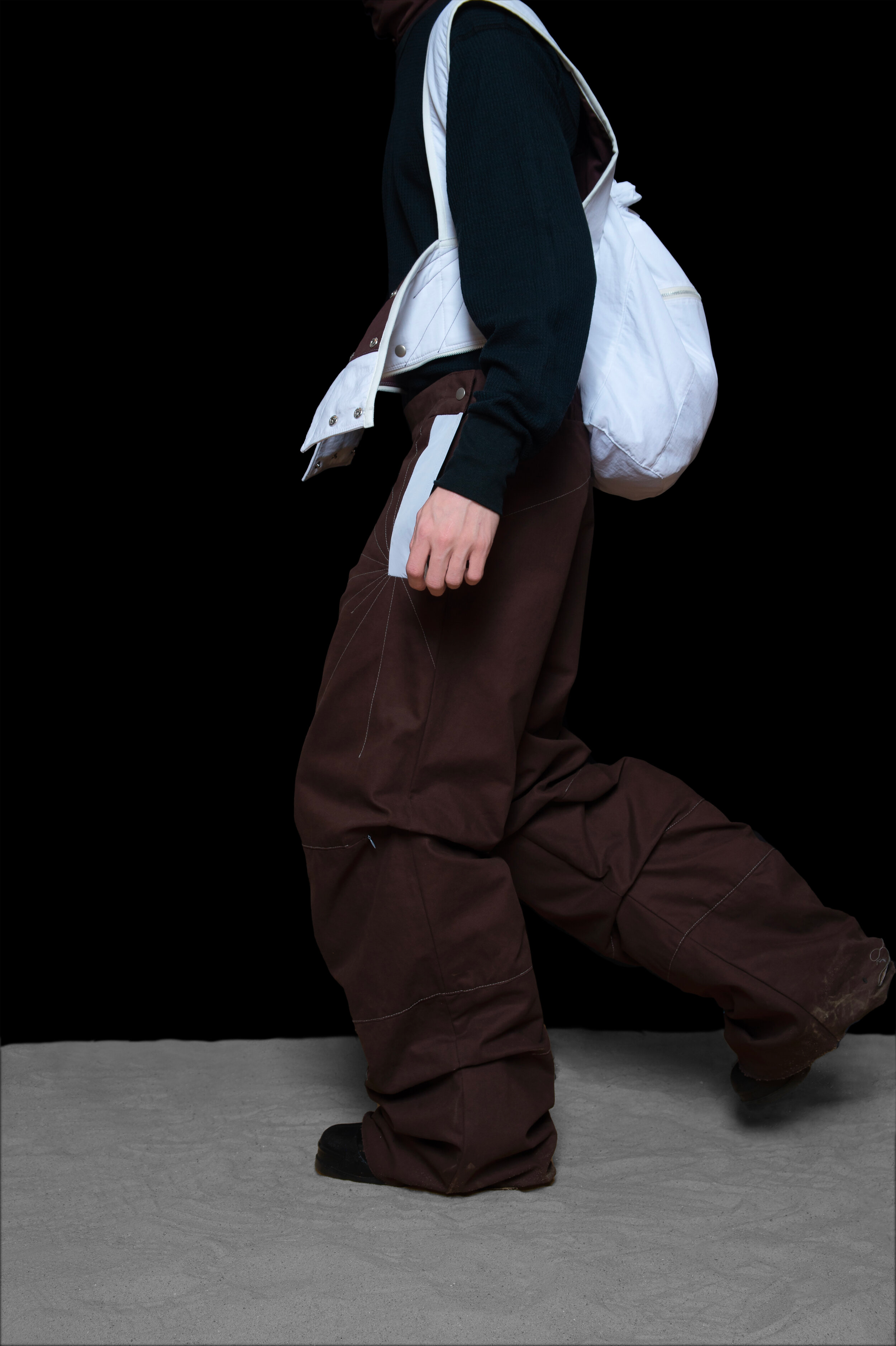 profile view of man wearing tactical head scarf, oxygen bag, and darted trousers from bryan jimenez fall winter 2020