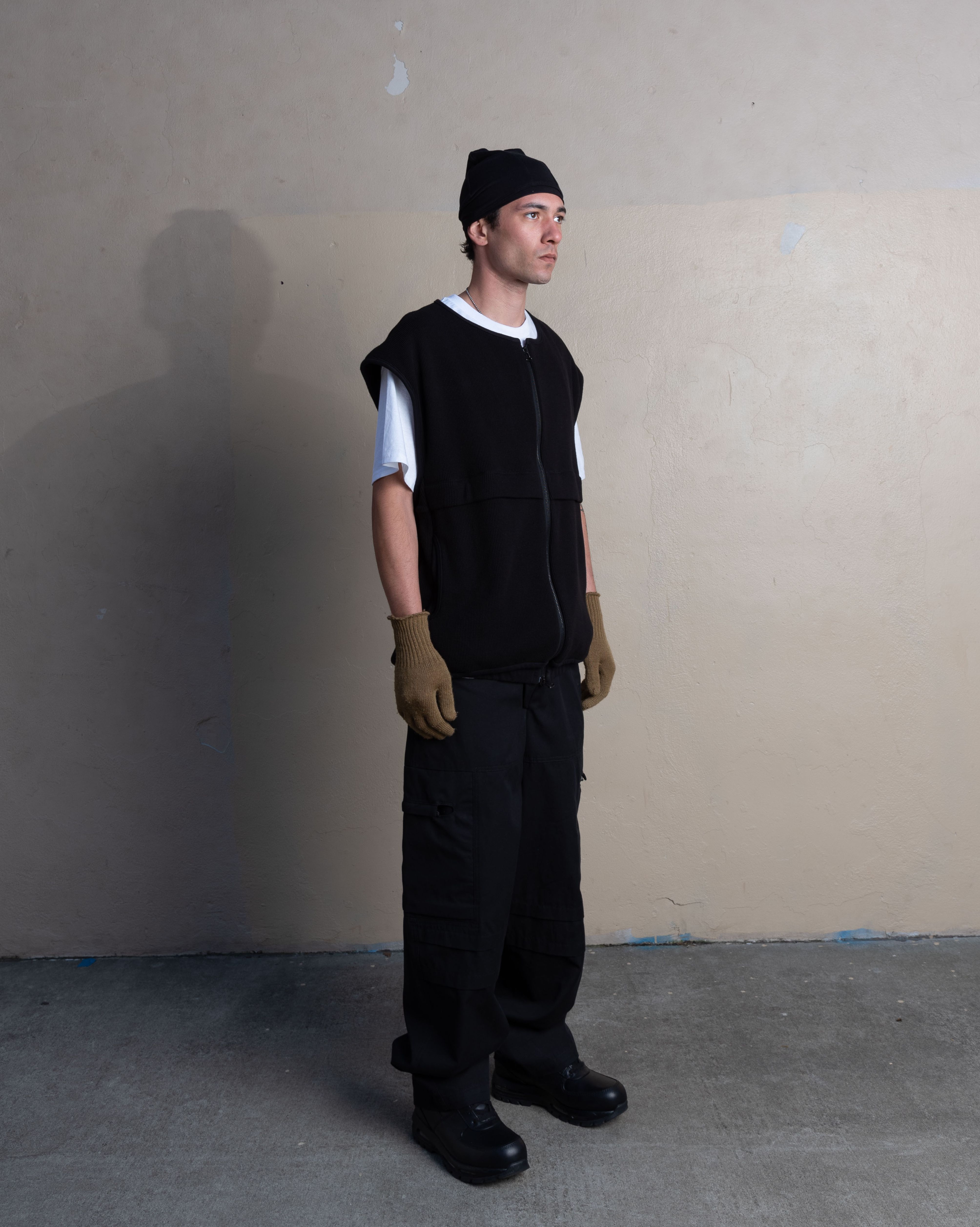man wearing bias taped skullcap, ventilation vest, and station trousers from bryan jimenez spring summer 2023