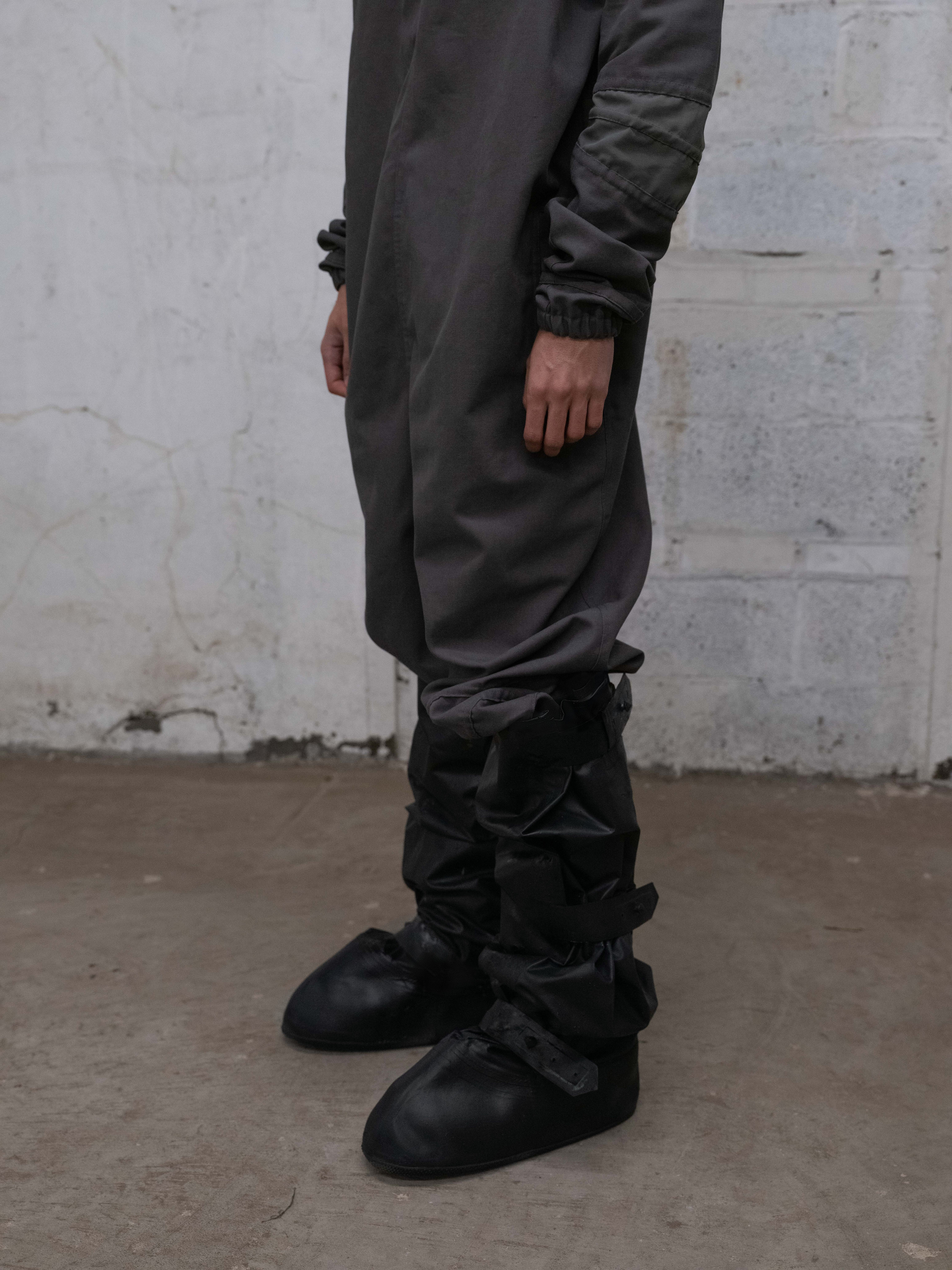 close view of man wearing anti exposure suit and cover boots from bryan jimenez fall/winter 2022