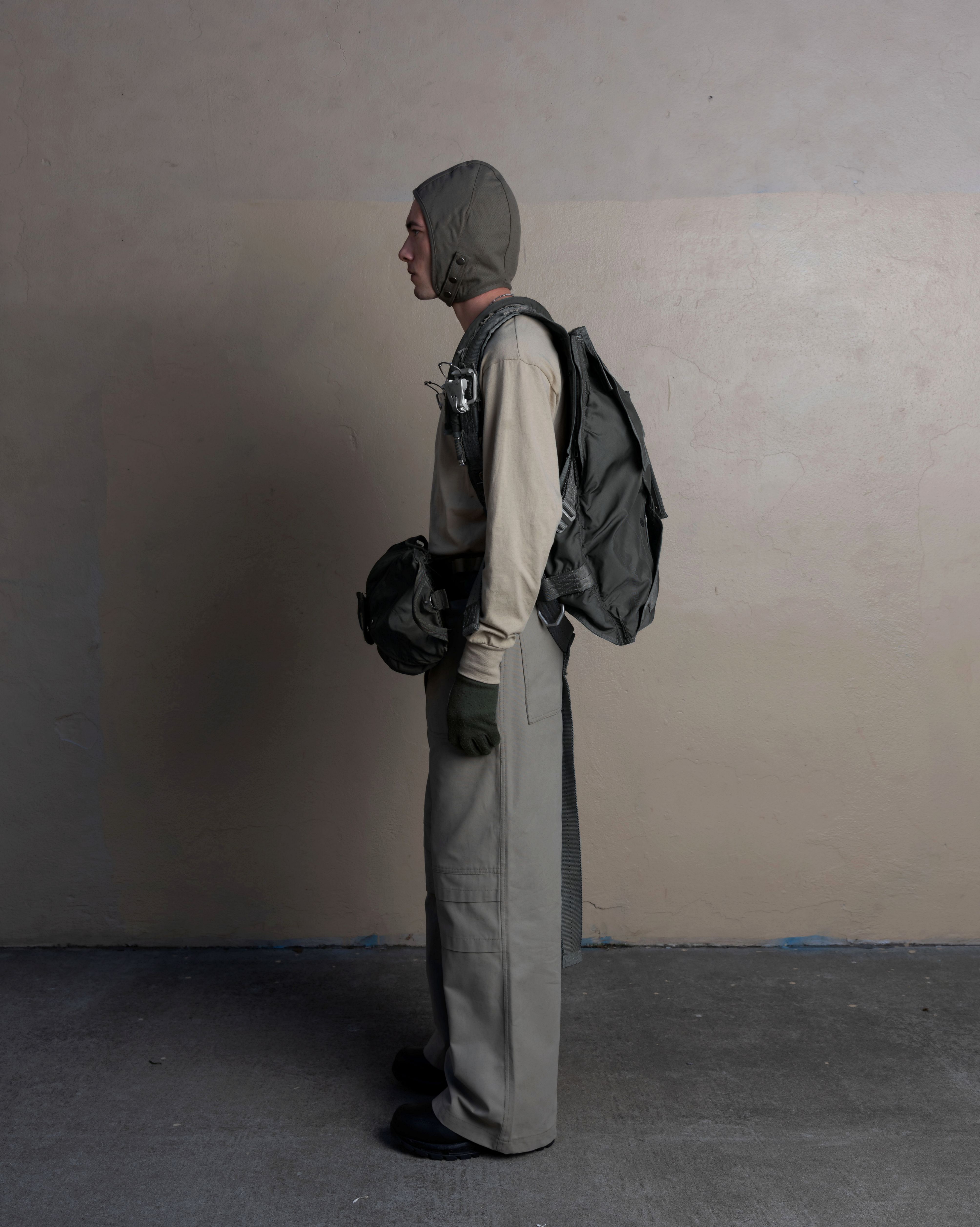 profile view of man wearing aviator headcap, undergarment long sleeve, and uniform trousers from bryan jimenez spring/summer 2023