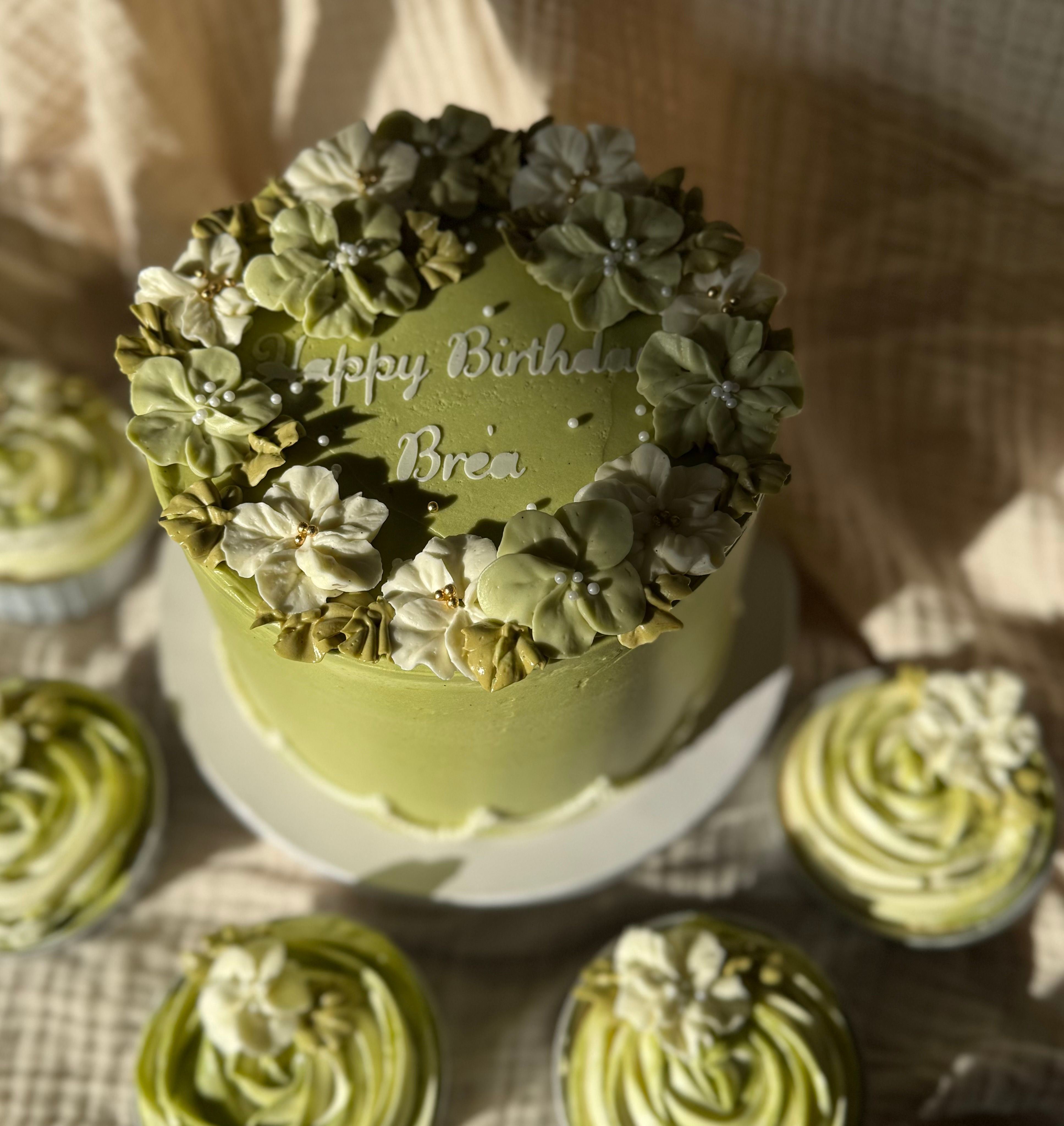 Sage green birthday cake with hand-piped buttercream flowers & matching cupcakes 
