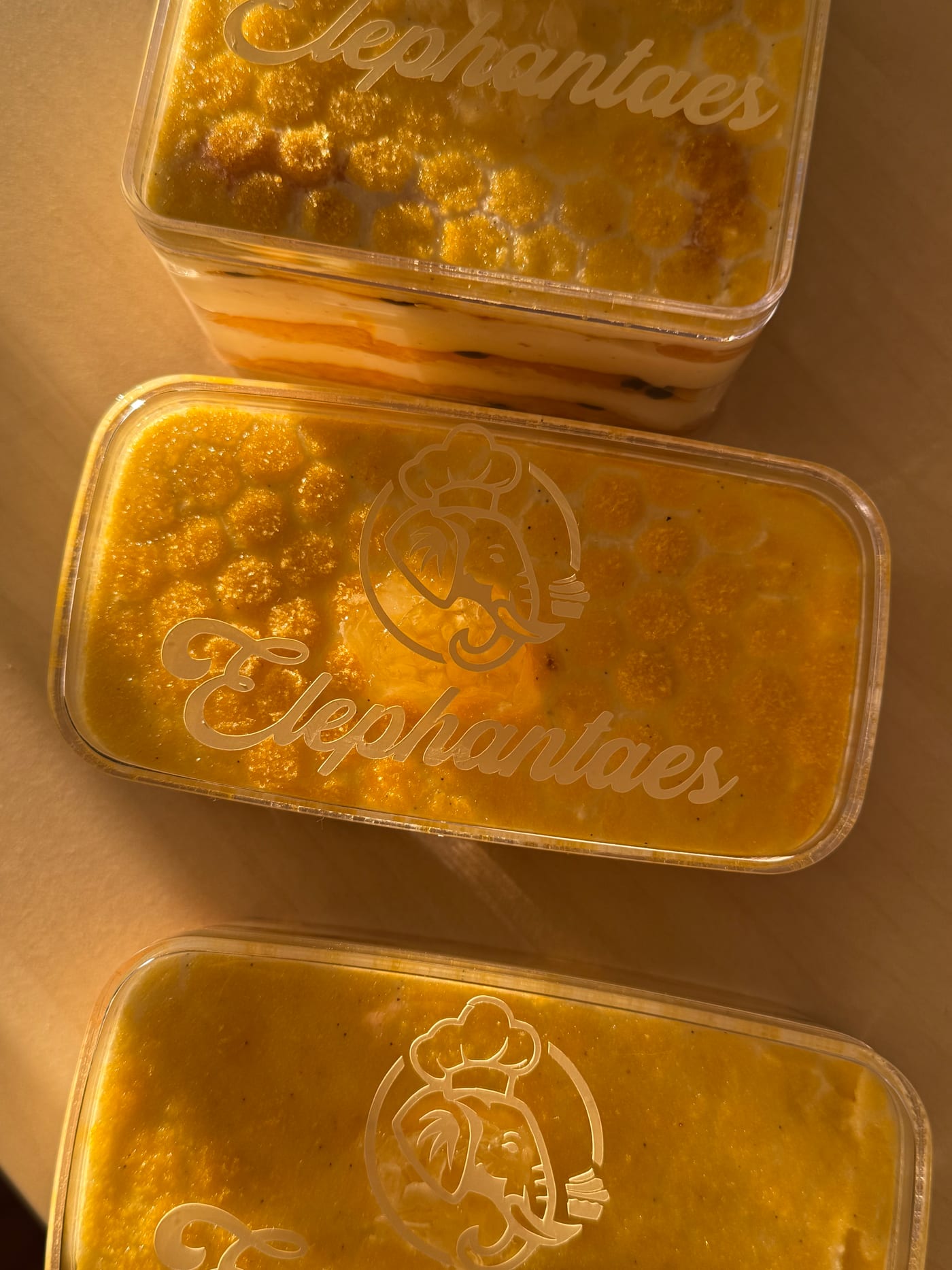 Three passion fruit honeycomb tiramisus in warm light
