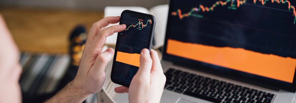 Reviewing live market data on a phone and laptop