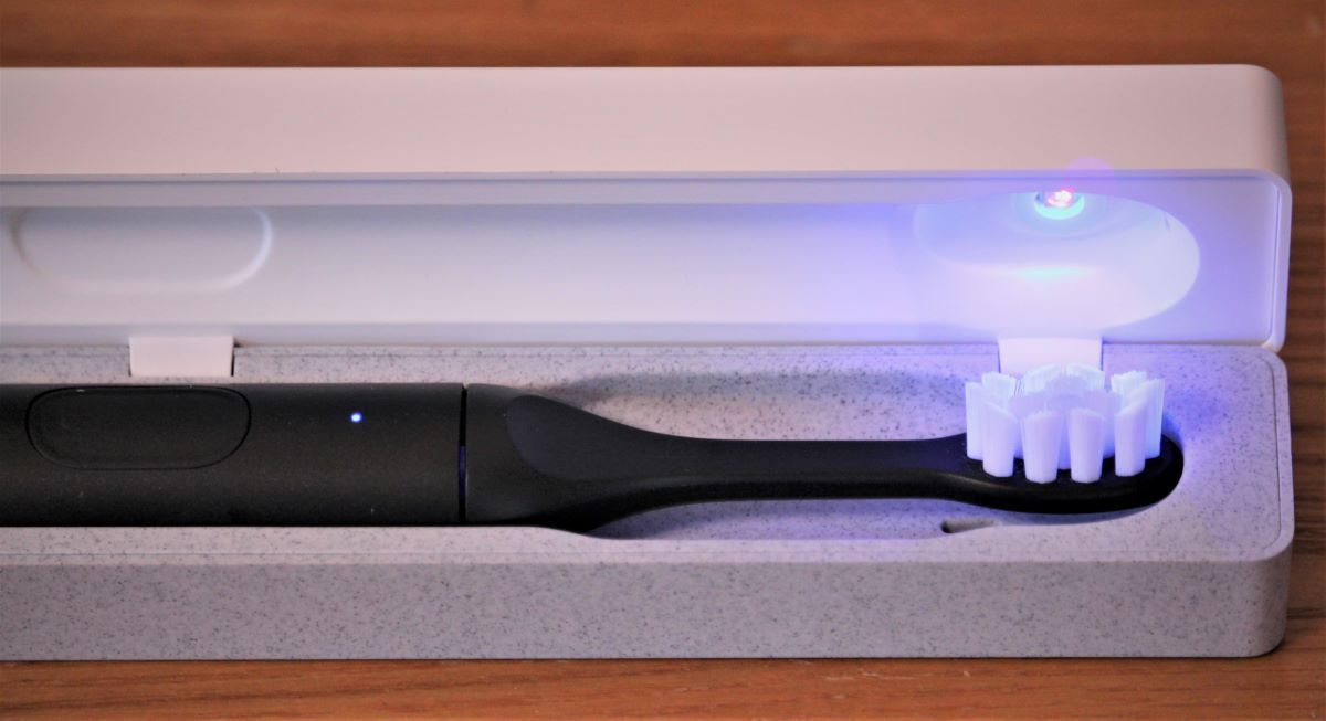 Image of SURI electric toothbrush inside travel case with UV-C cleaning cycle active