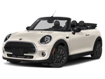 a white convertible mini cooper viewed from the front corner.