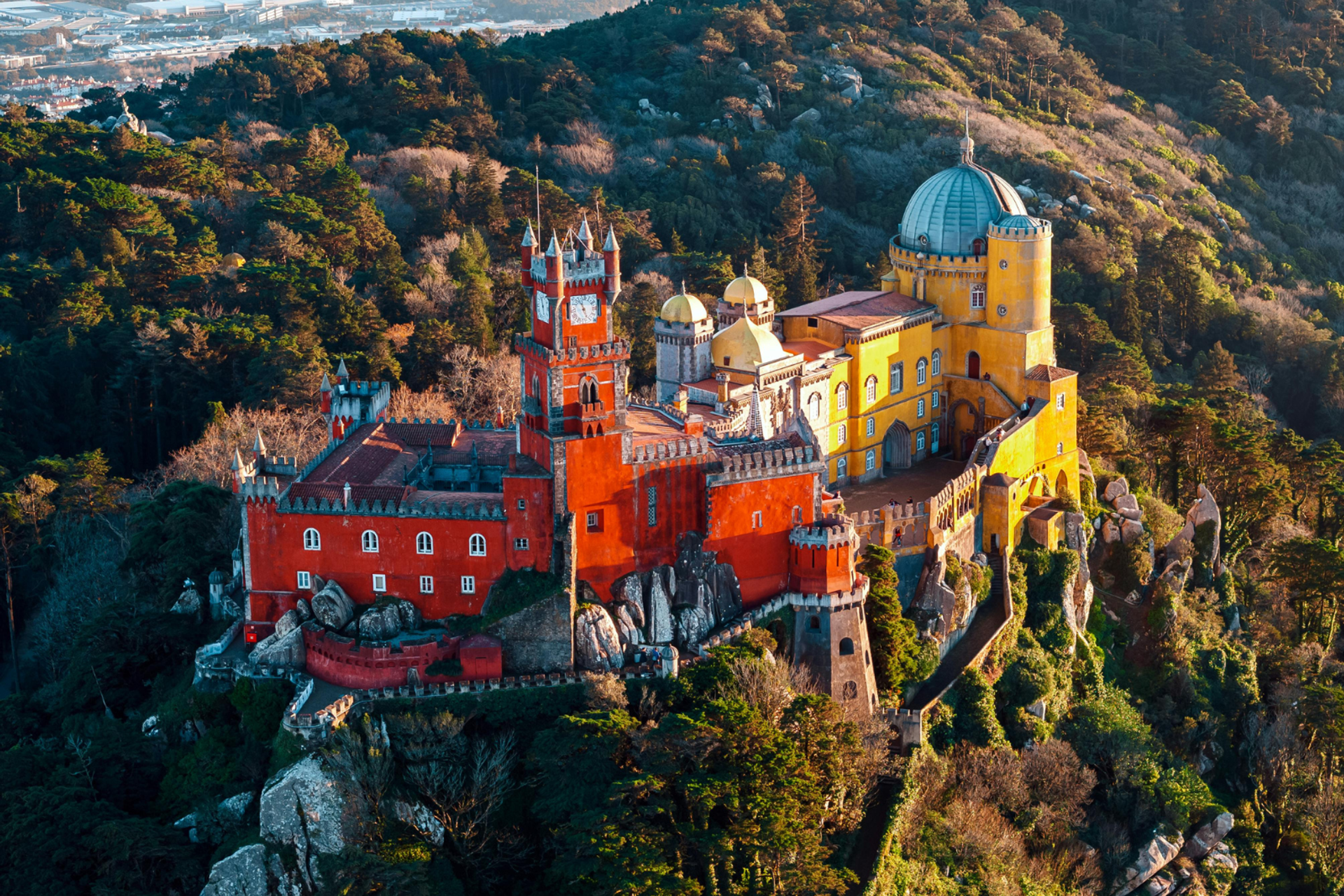 Aerial view of Pena Palace rising above the wooded hills of Sintra, Portugal.