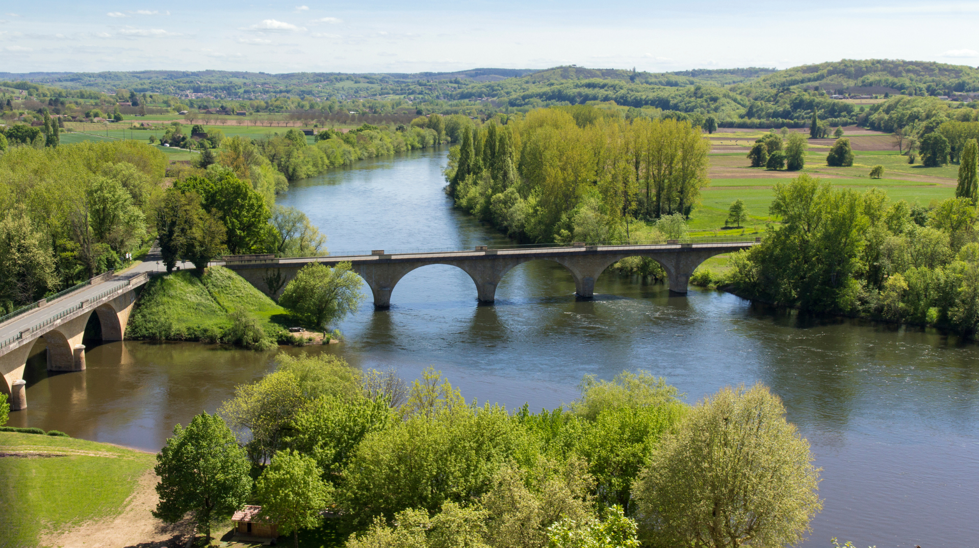 Vézère Valley landscape with river, stone bridge and wooded countryside