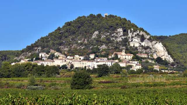 Séguret village beneath a wooded limestone hillside in Provence
