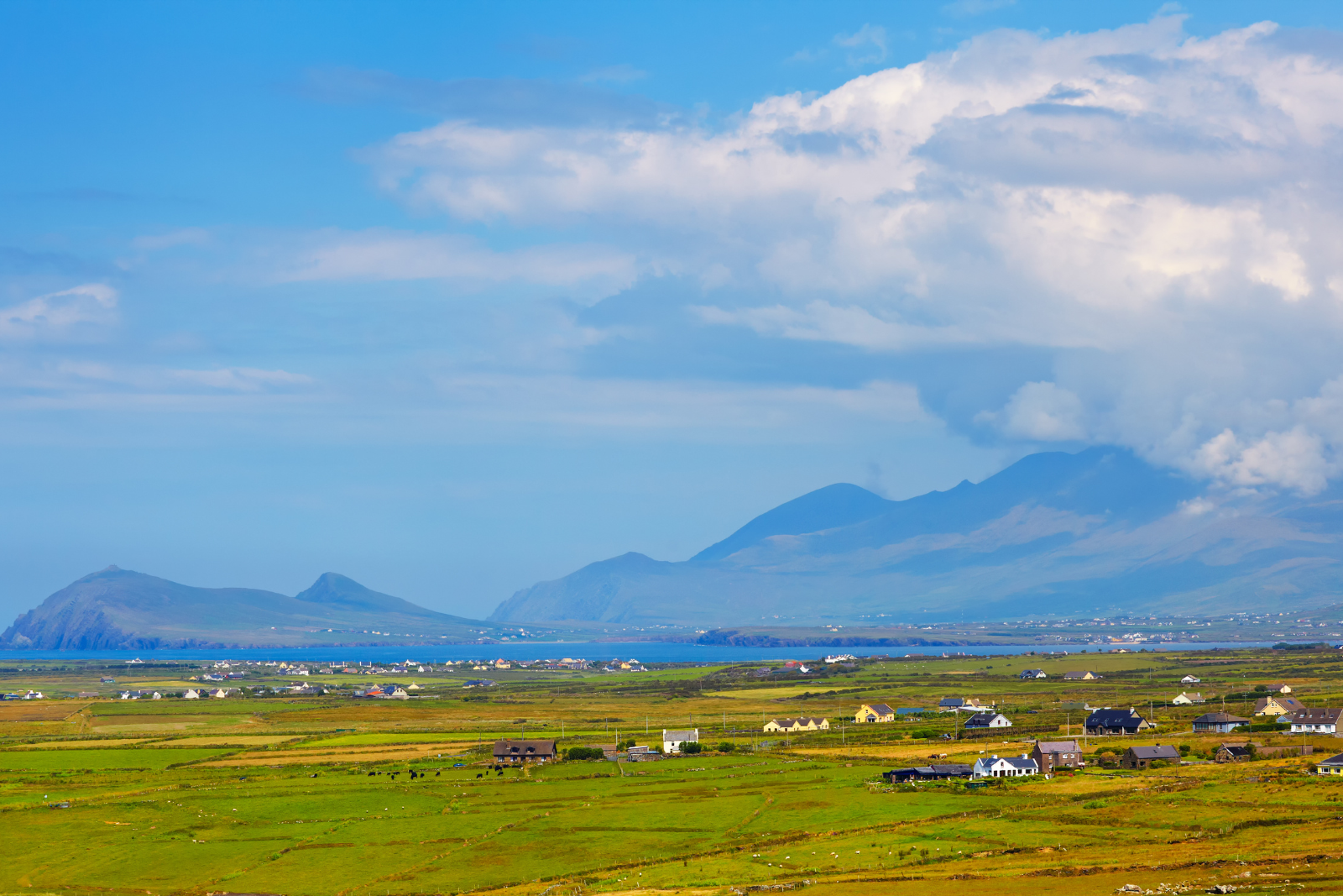 Mount Brandon rising above fields and scattered houses on the Dingle Peninsula.