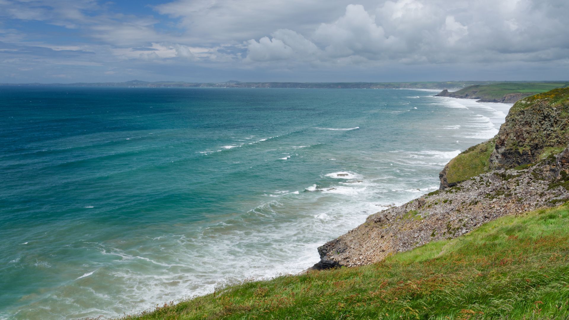 Clifftop view along the Pembrokeshire Coast Path above a long sweep of surf.