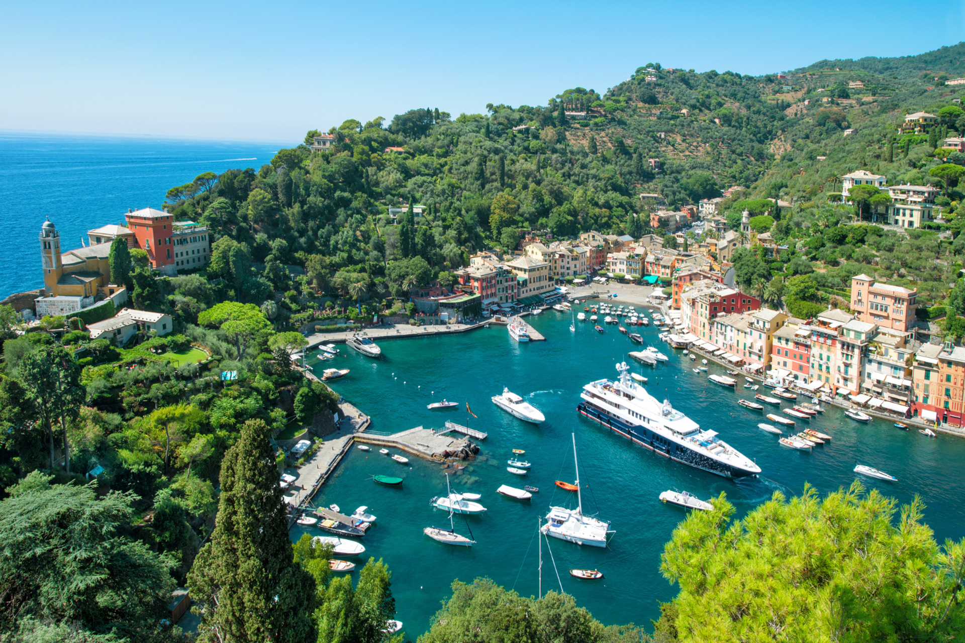 Portofino harbour seen from above, surrounded by wooded hillsides.