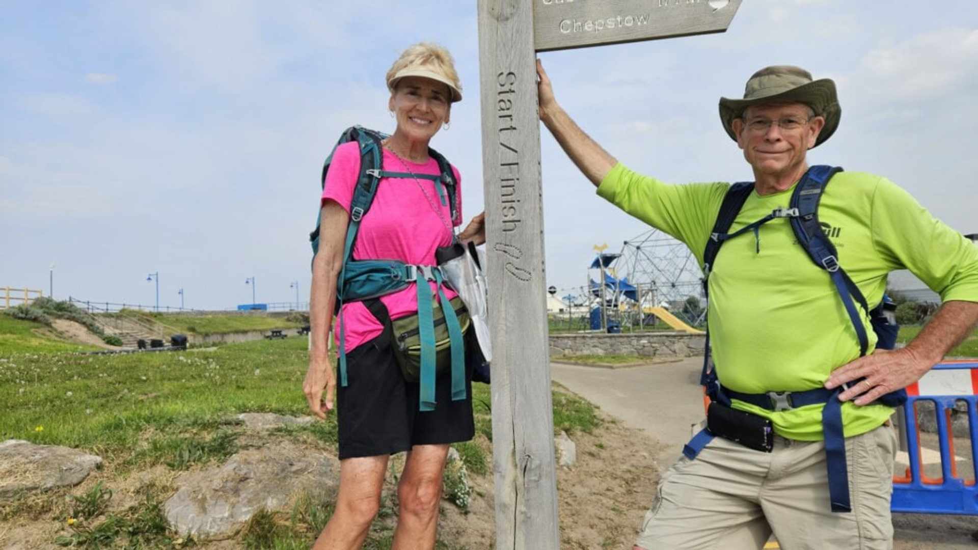 Two people posing for a photograph next to a sign indicating the start/finish of the Wye Valley Way.