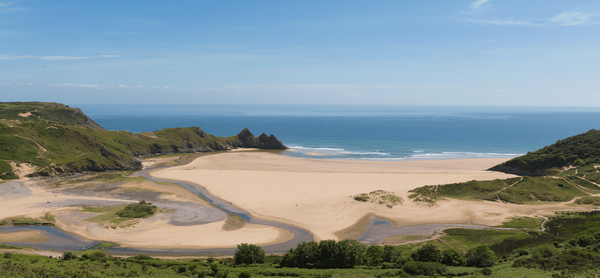 Three Cliffs Bay on the Gower Coast Path with limestone cliffs and wide sandy beach