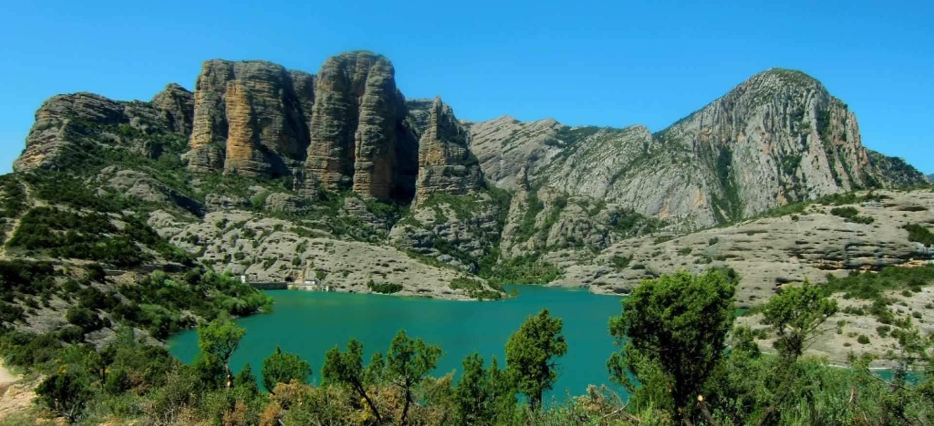 Turquoise reservoir beneath limestone cliffs in the Sierra de Guara, Aragon