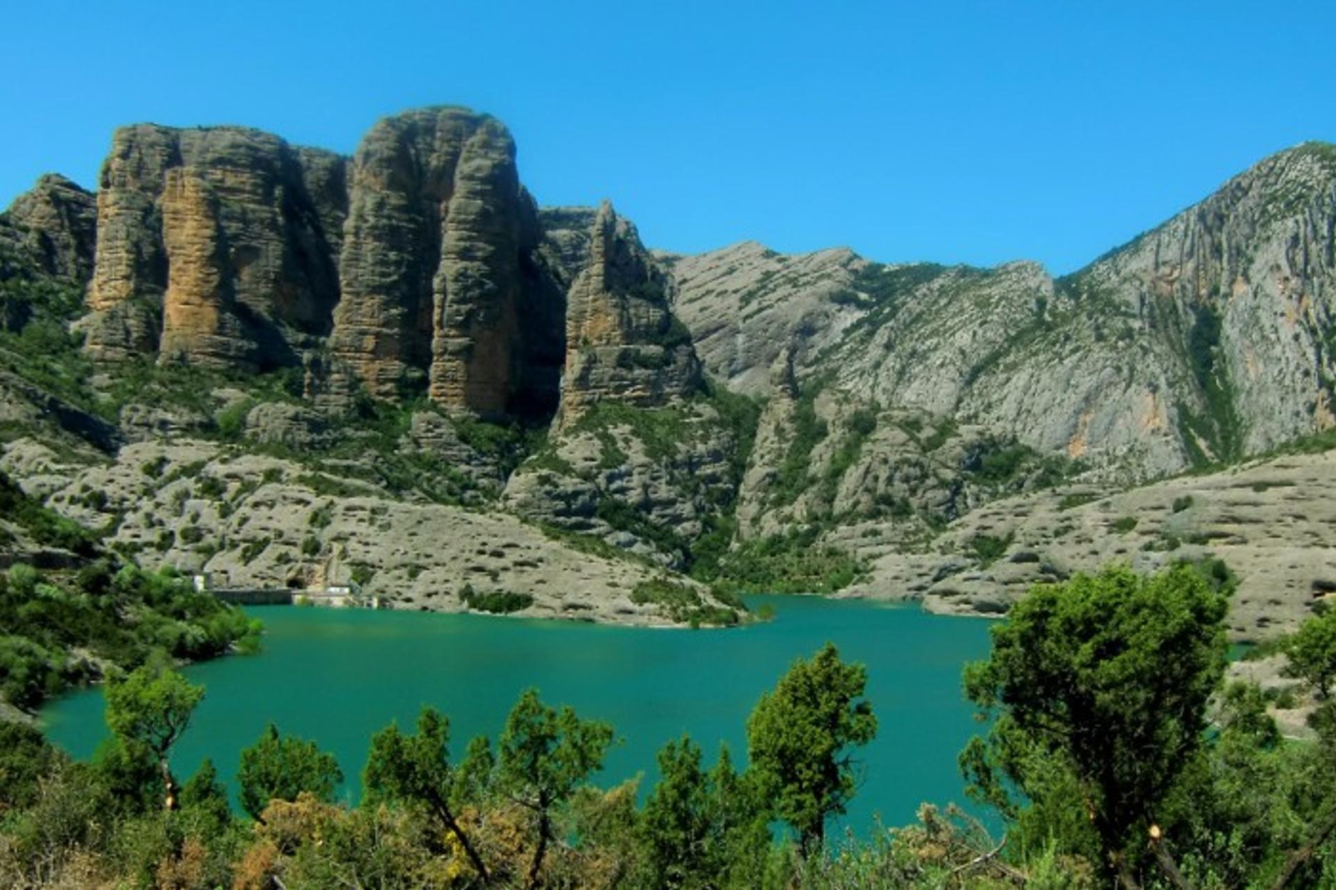 Turquoise reservoir beneath limestone cliffs in the Sierra de Guara, Aragon
