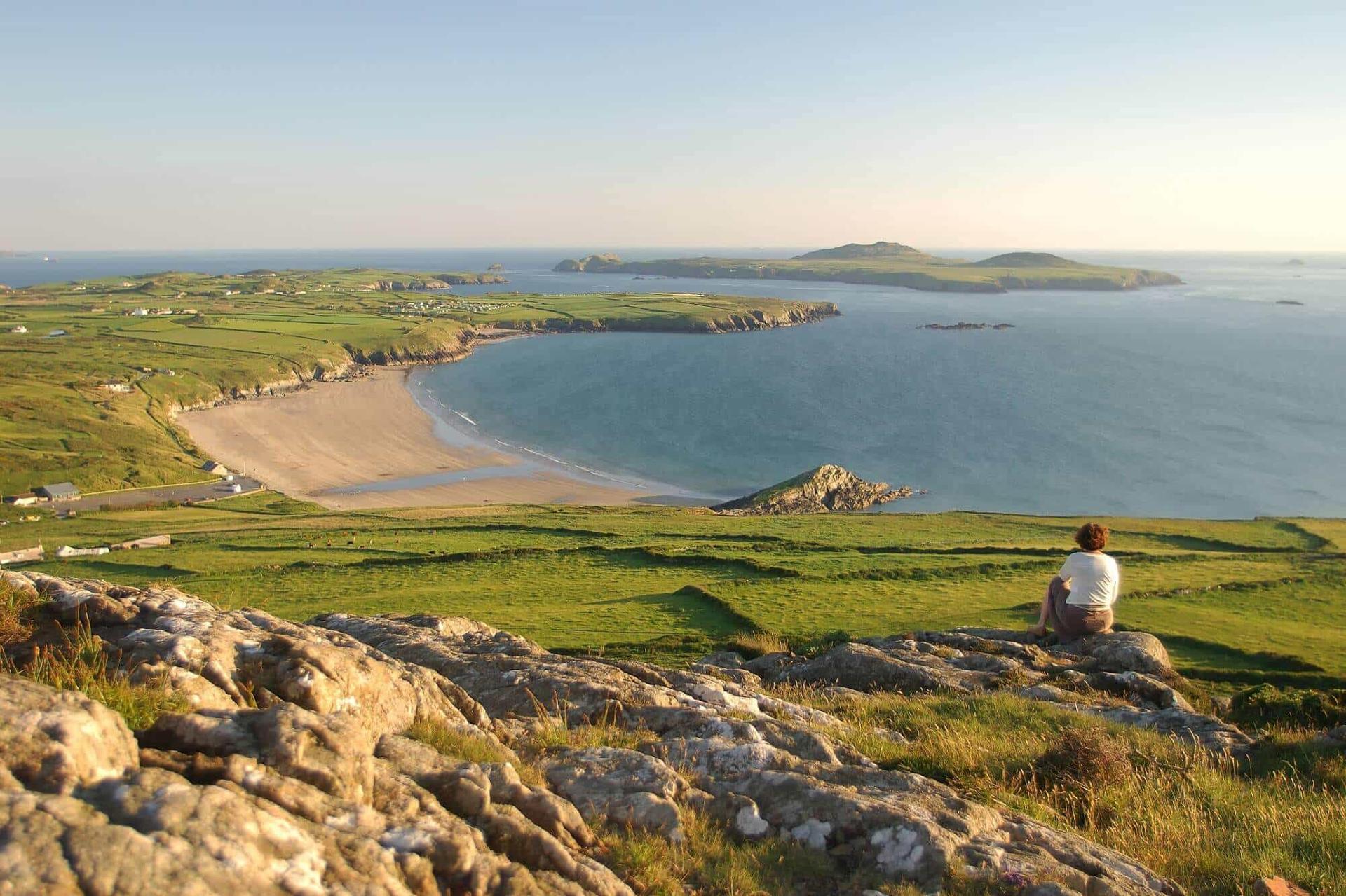 Person sitting looking out over a beautiful Pembrokeshire beach
