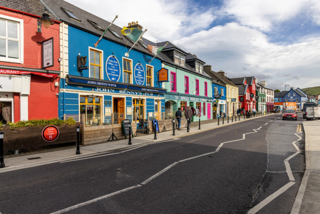 Colourful shopfronts lining a street in Dingle town, County Kerry.