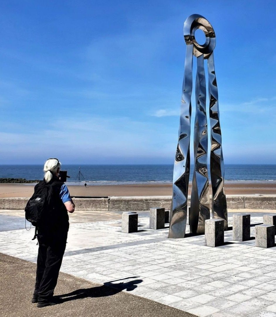 Walker at the finish of the Offa's Dyke Path in Prestatyn