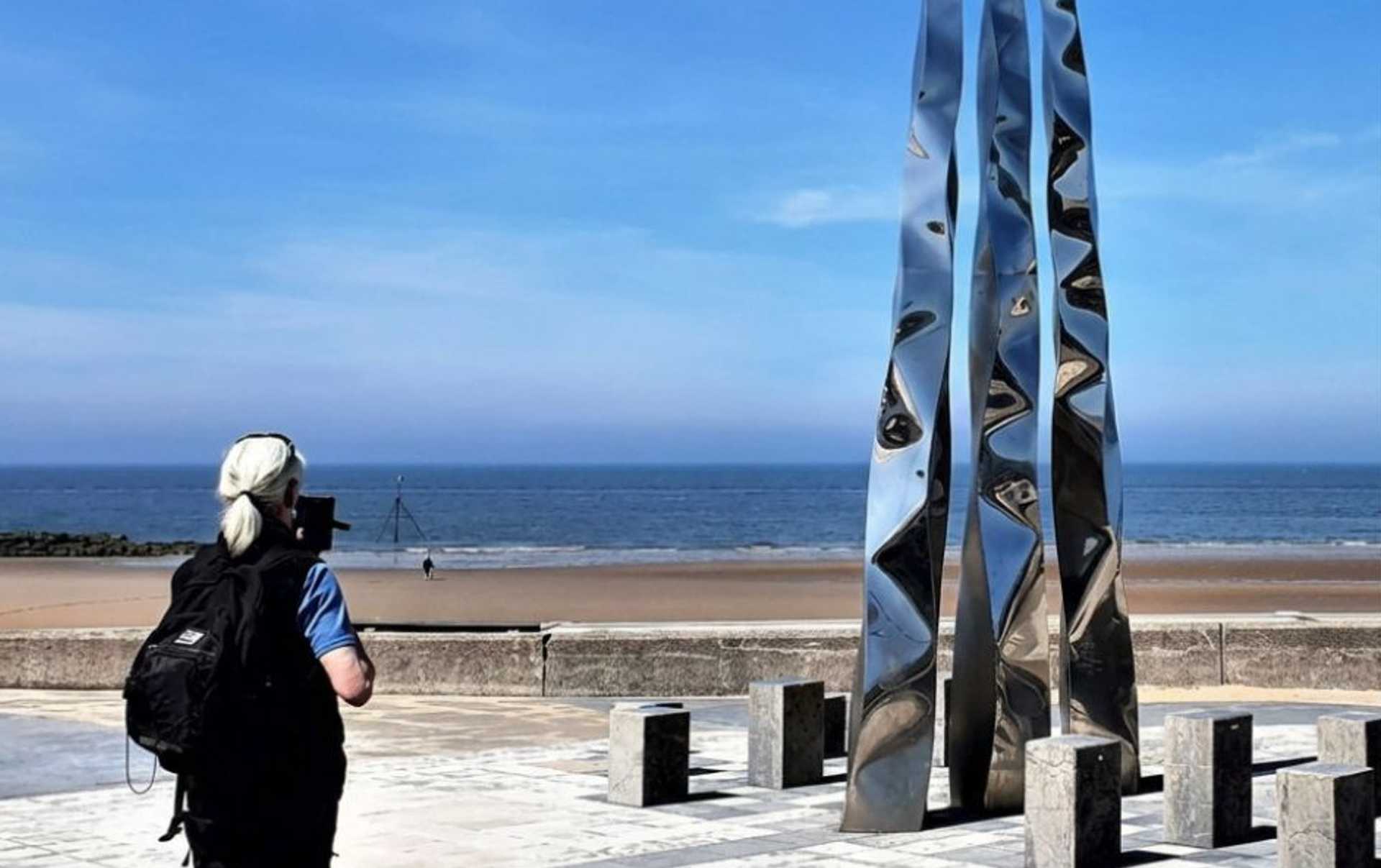 Walker at the finish of the Offa's Dyke Path in Prestatyn