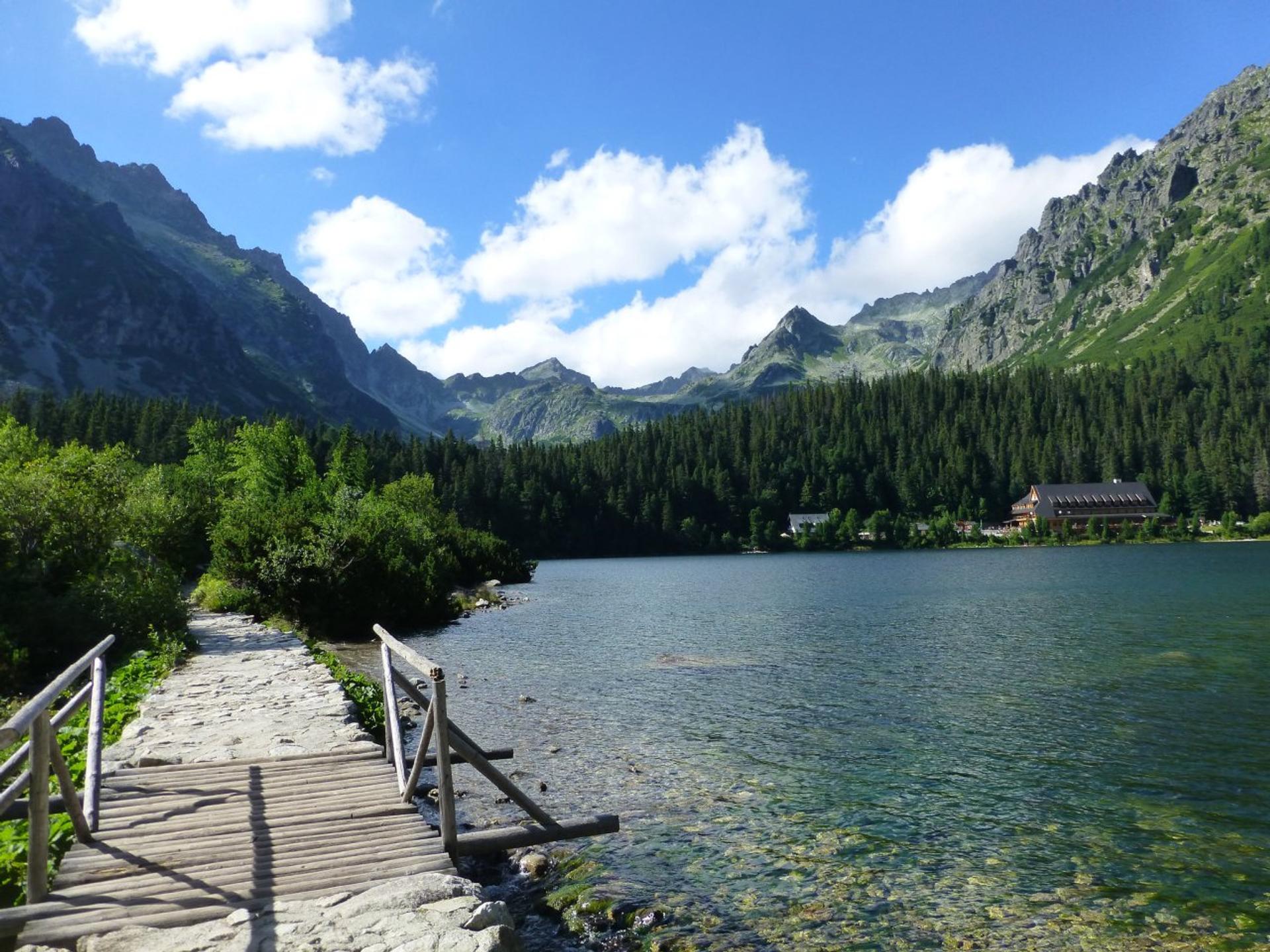 Štrbské Pleso mountain lake with surrounding forest and High Tatras peaks reflected in the water
