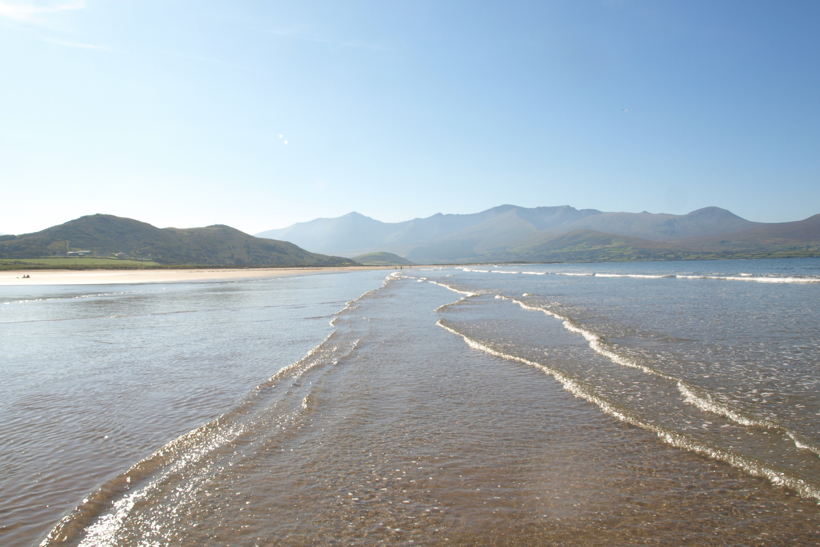Shallow water and broad sands at Fermoyle Strand with mountains beyond.