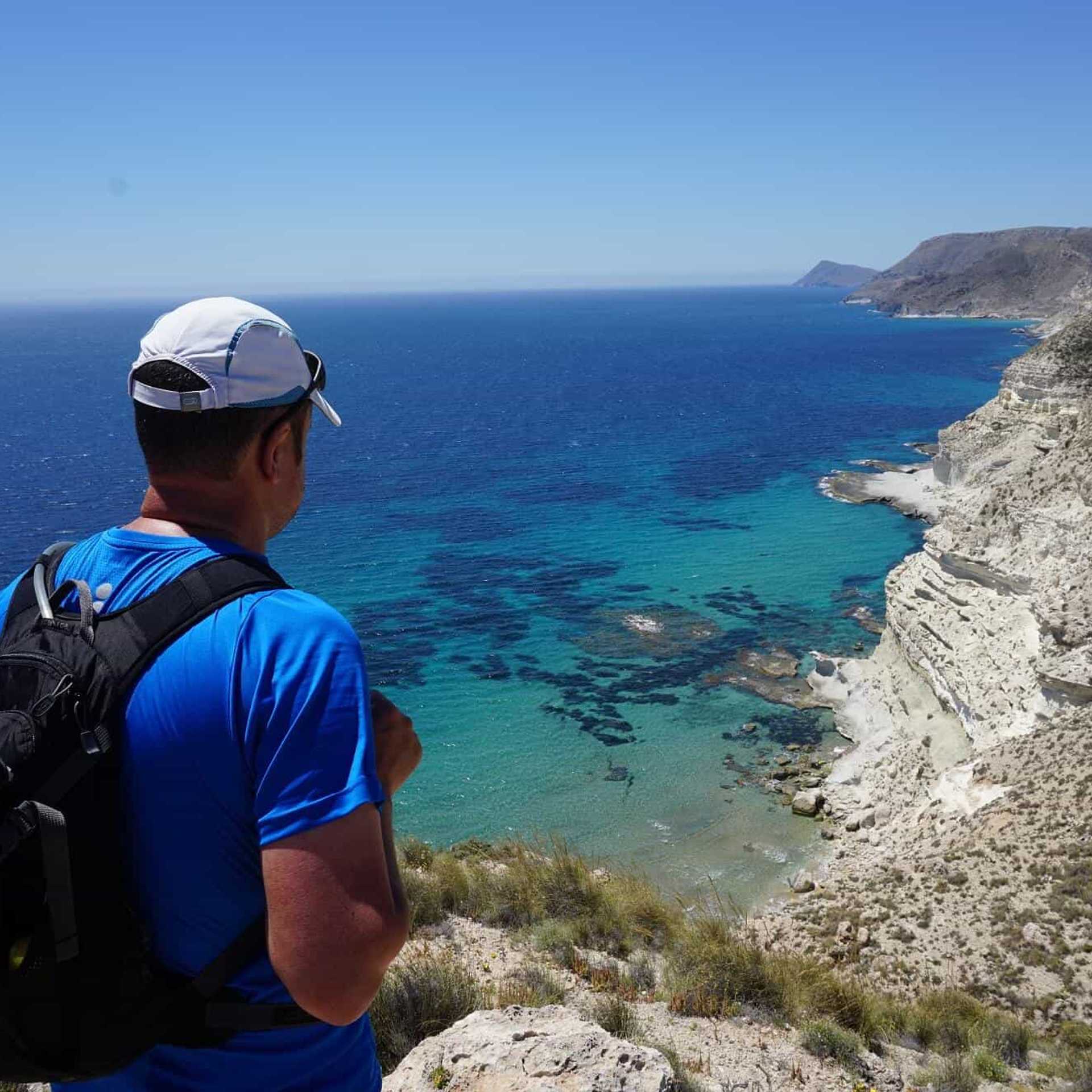 Walker looking out over a clear blue sea