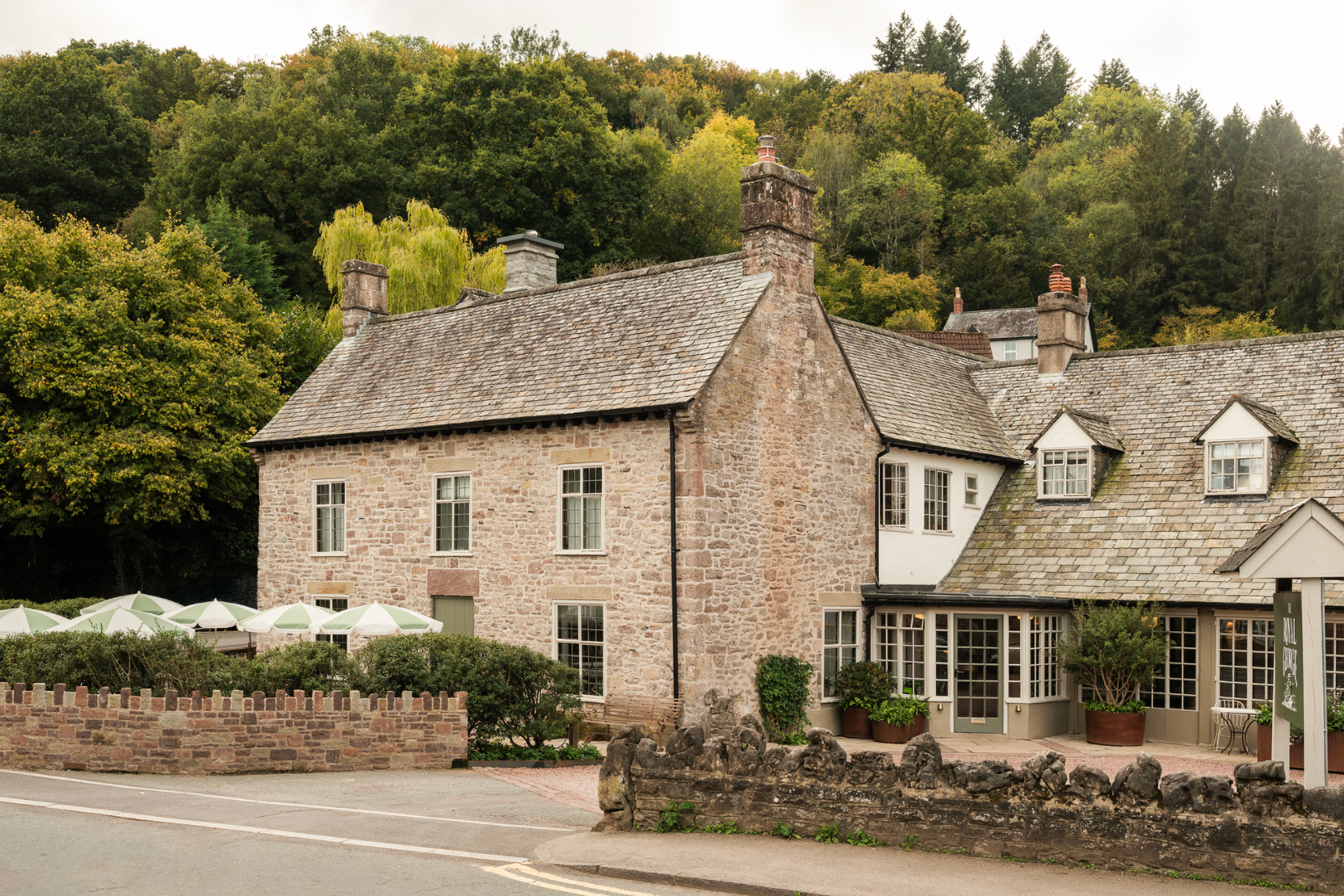 Stone-built country inn beside woodland.