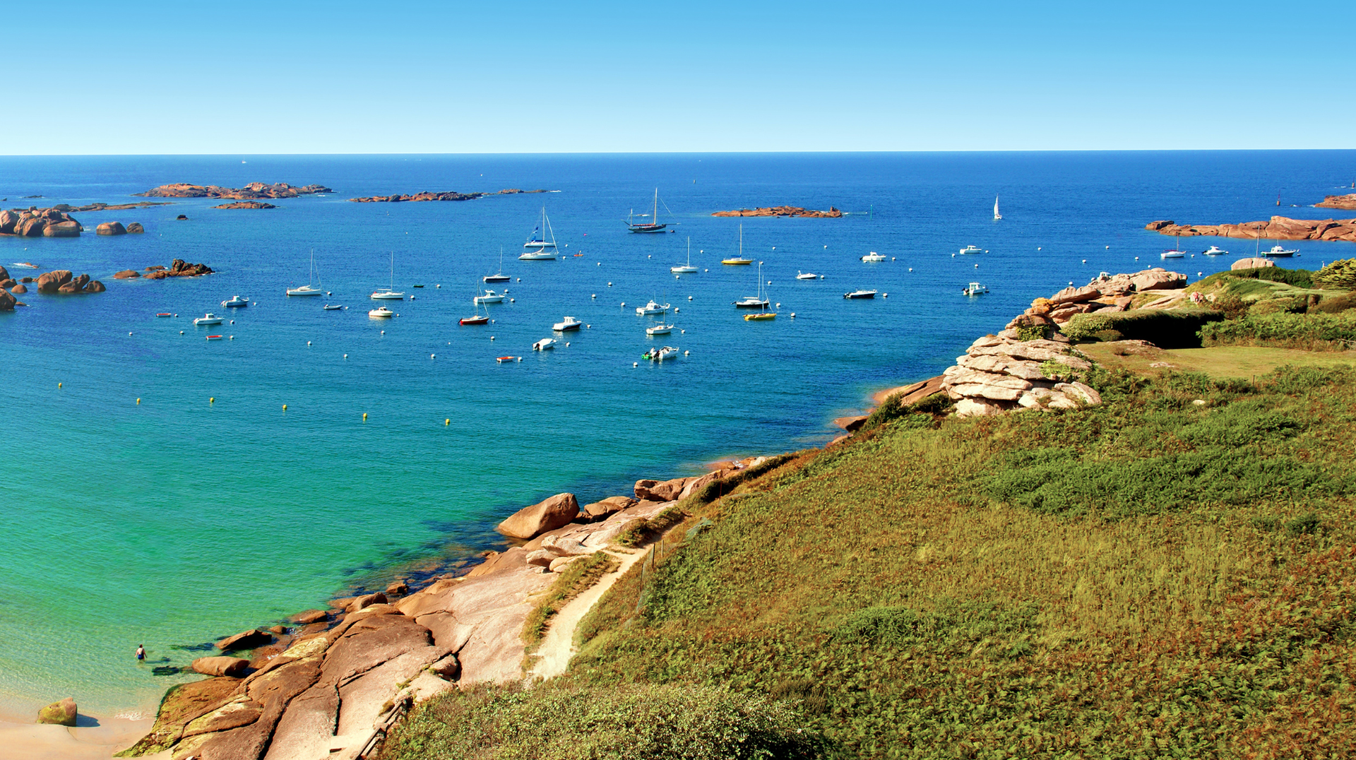 Boats moored off the rocky coast at Trégastel in Brittany