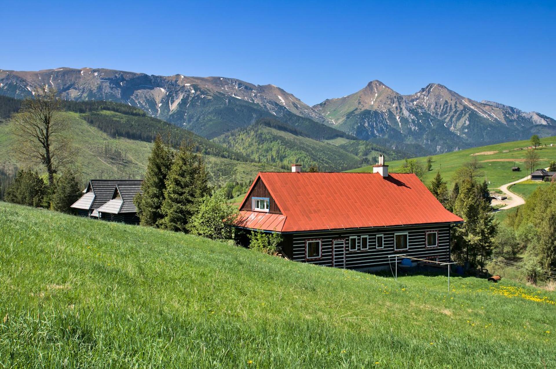 Traditional wooden Goral houses near Ždiar with the High Tatras in the background
