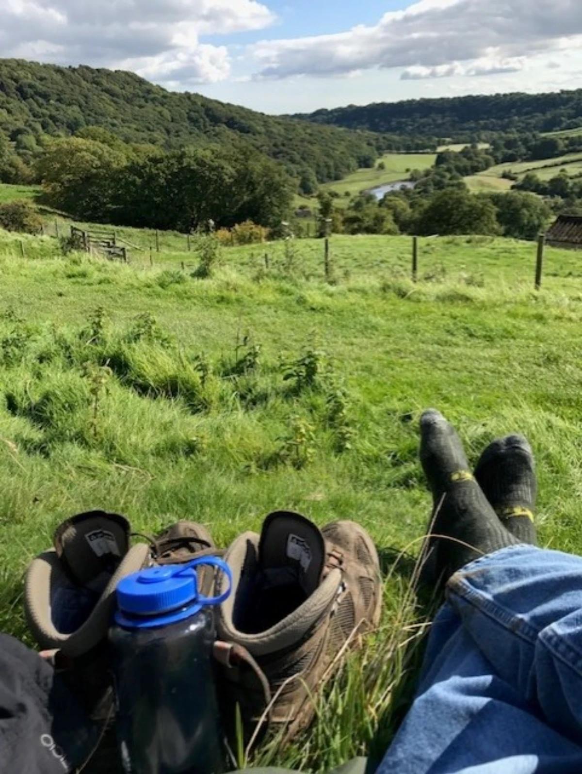 Walking boots resting in grass with valley views on the Coast to Coast Walk