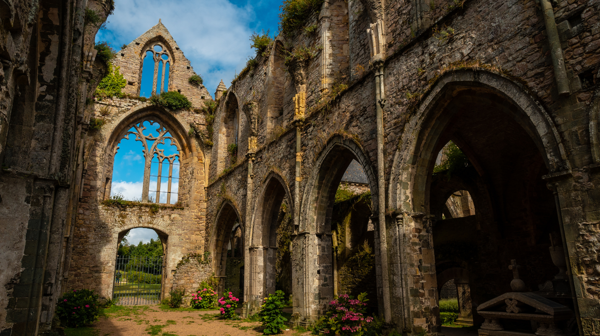 Ruined stone arches and gardens at Beauport Abbey near Paimpol