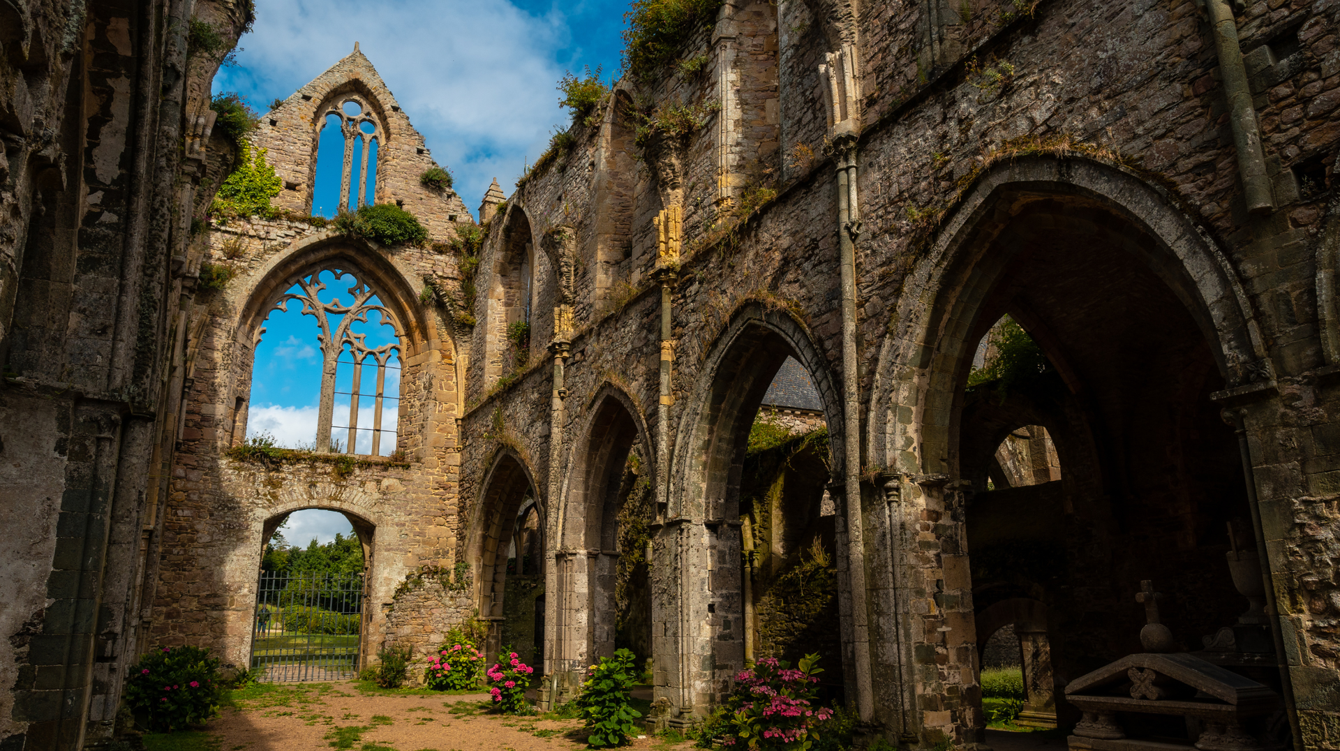 Ruined stone arches and gardens at Beauport Abbey near Paimpol