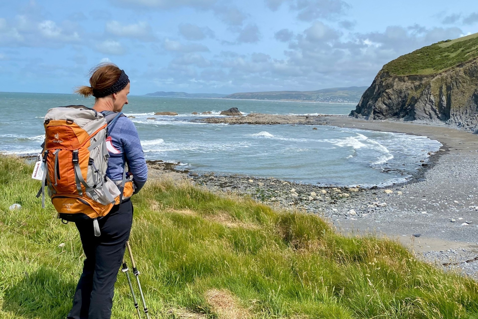 Walker on the Ceredigion Coast Path above a rocky bay