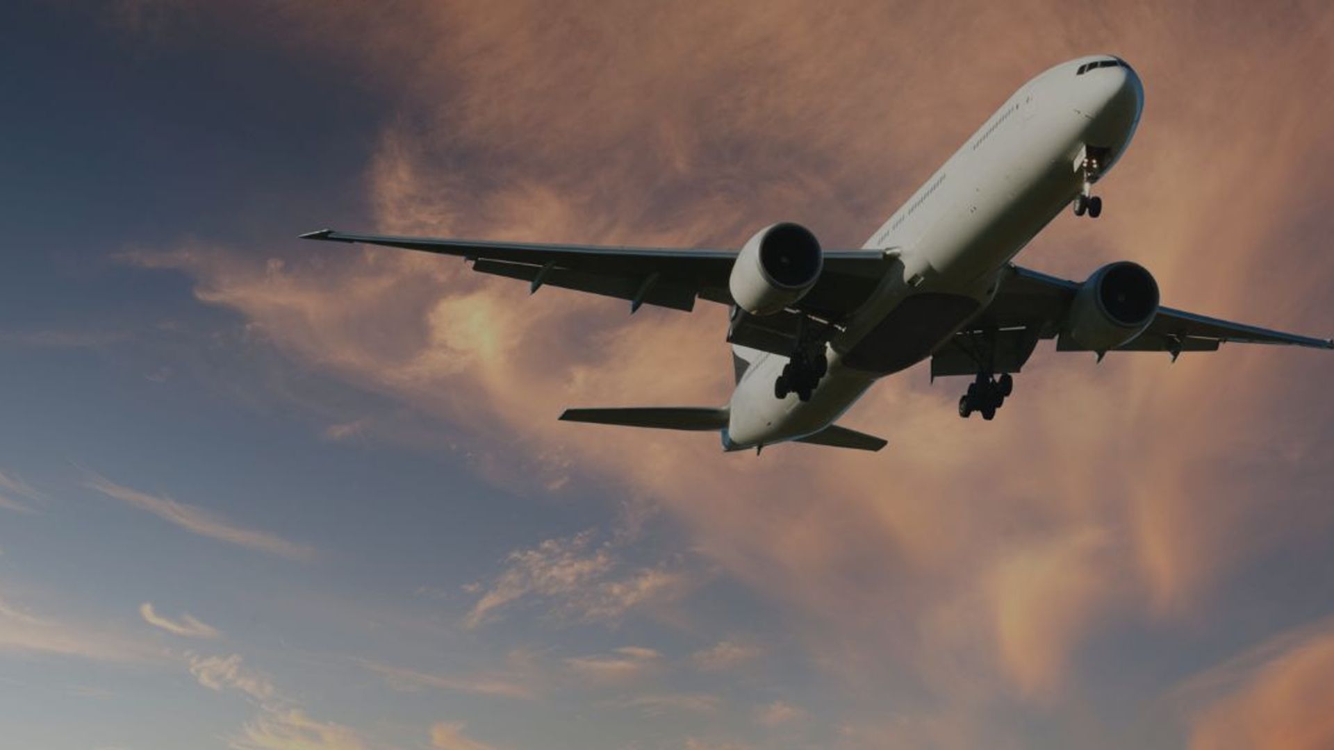 A large passenger jet aeroplane flying low overhead.